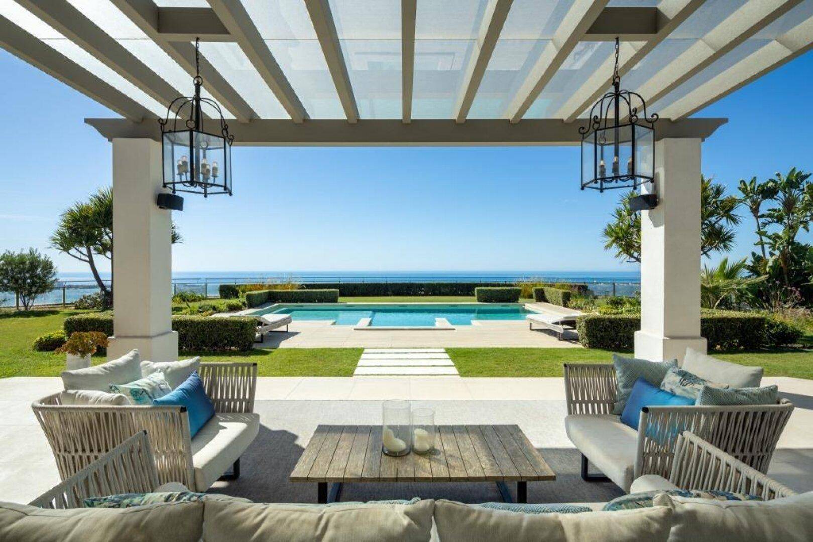Elegante überdachte Terrasse mit bequemen Sitzmöbeln und weitem Meerblick.