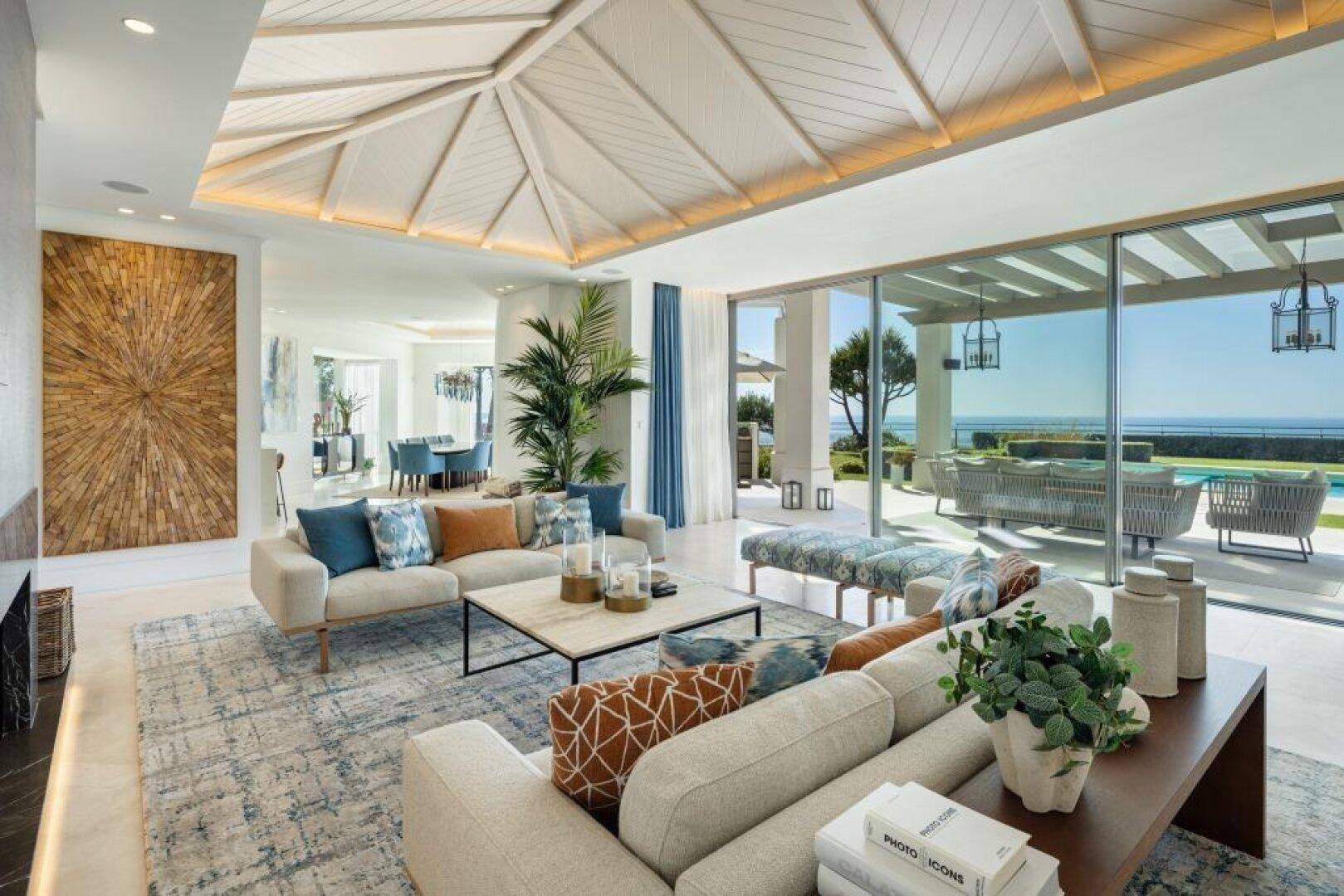 Geräumiges Wohnzimmer mit Meerblick, hohen Decken und Zugang zur Terrasse.