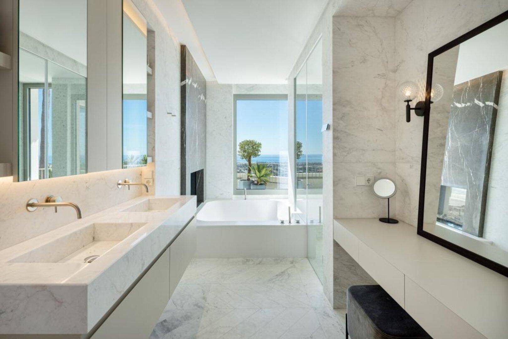 Luxuriöses Badezimmer mit Doppelwaschbecken, Badewanne und Meerblick.