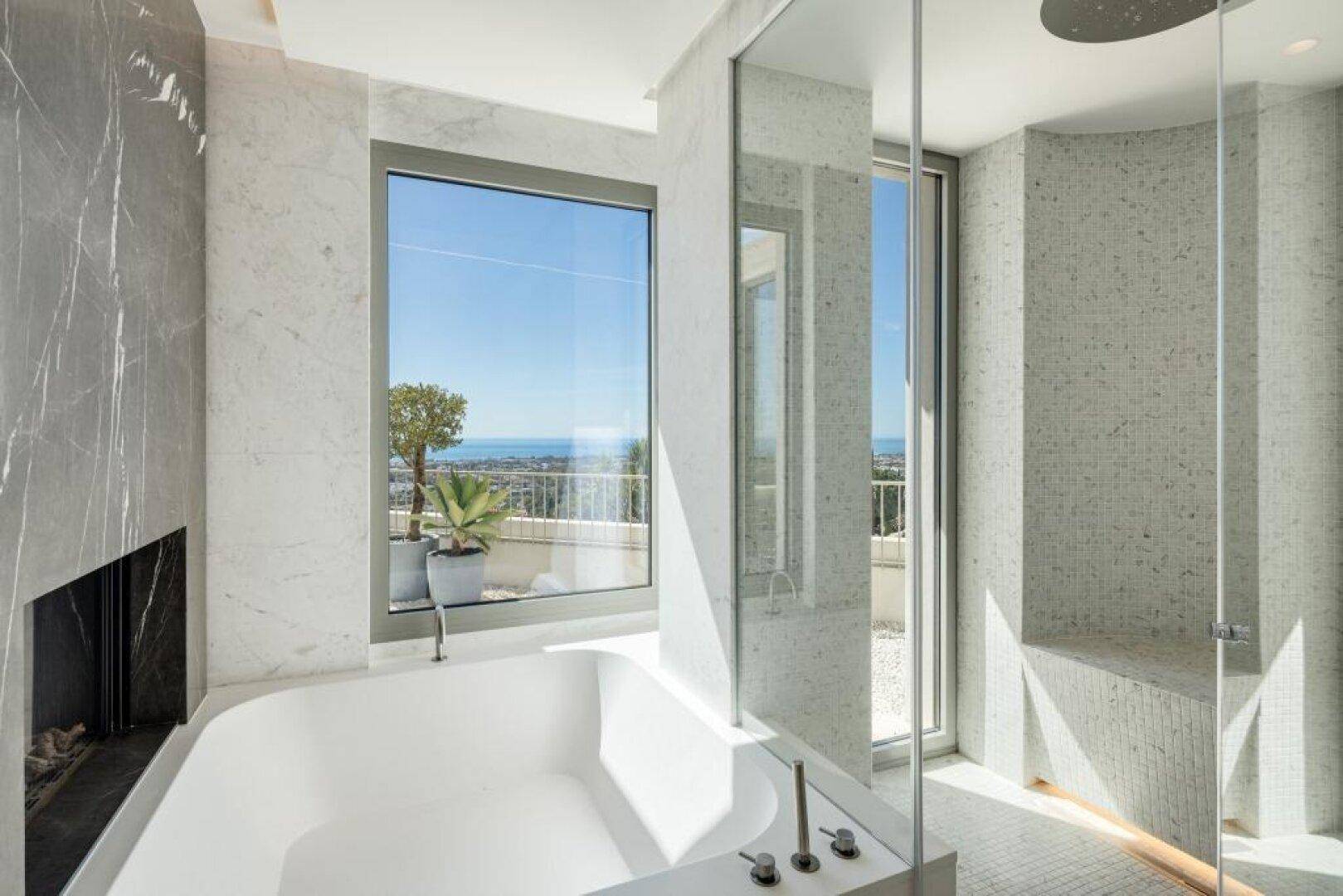 Modernes Badezimmer mit Badewanne, begehbarer Dusche und Meerblick.