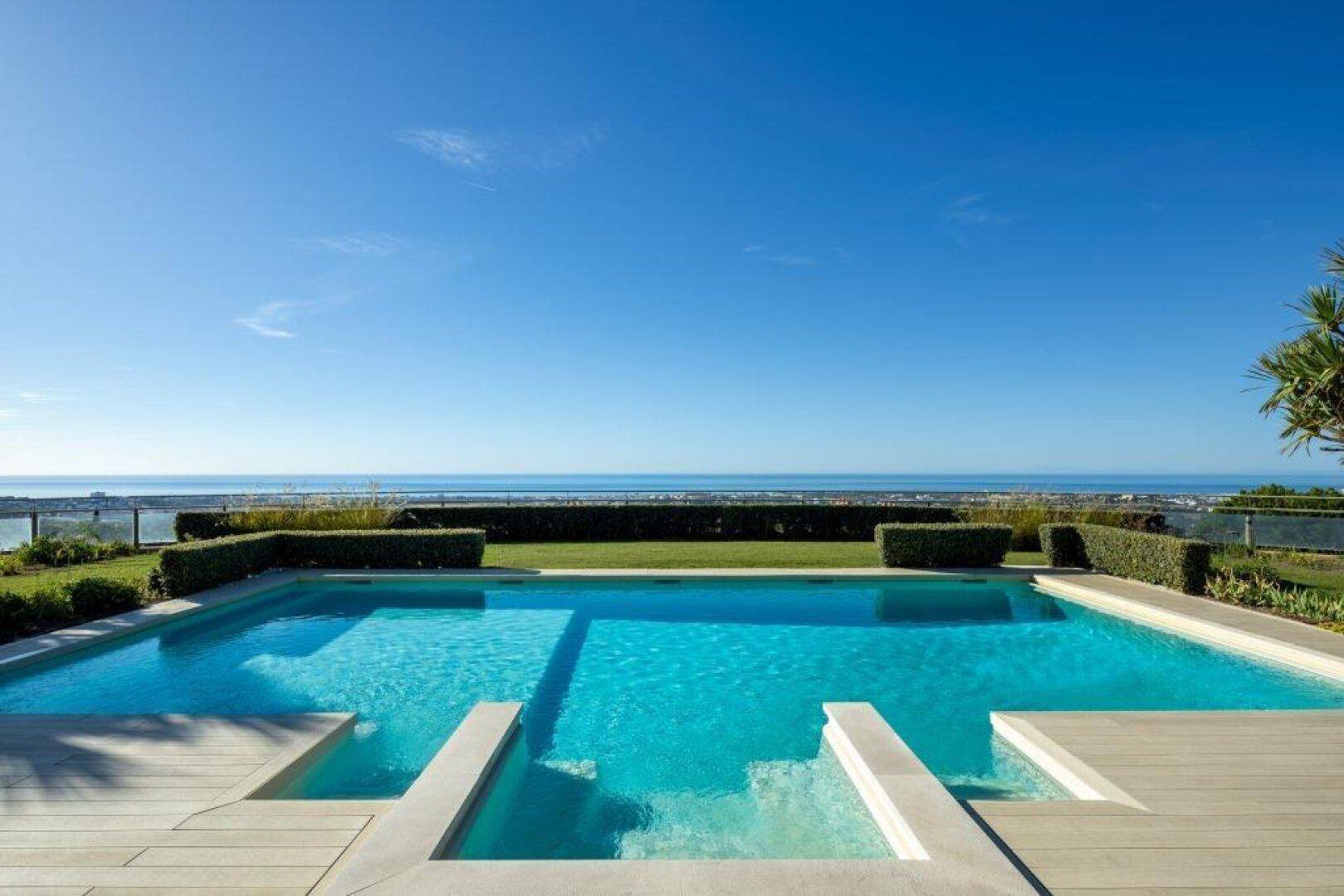 Erfrischender Poolbereich mit weitem Blick auf das Meer und den Horizont.