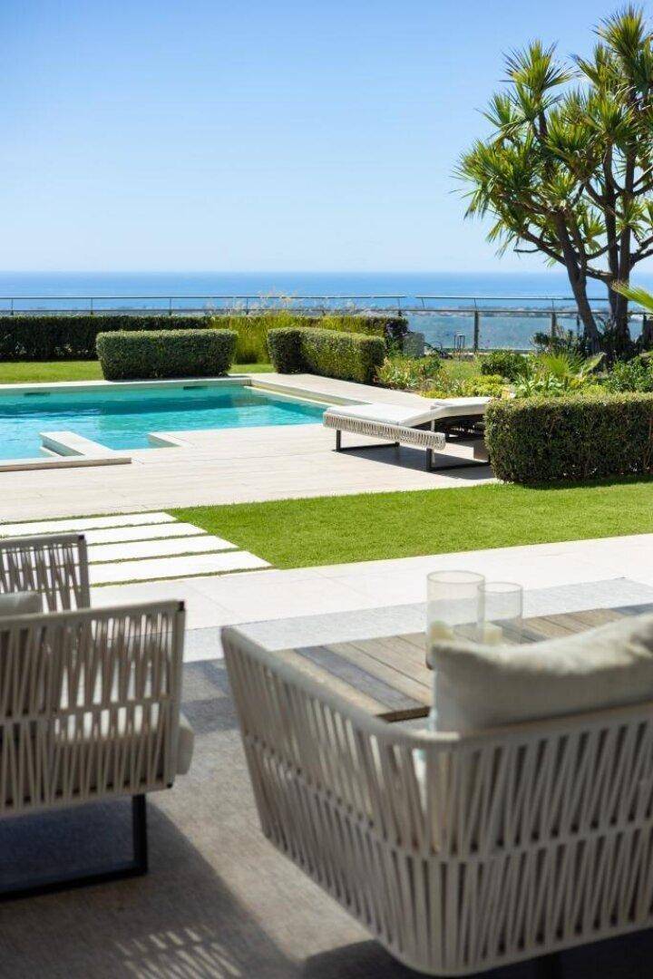 Gemütlicher Außenbereich mit Sitzgelegenheiten, Pool und Panoramablick auf das Meer.