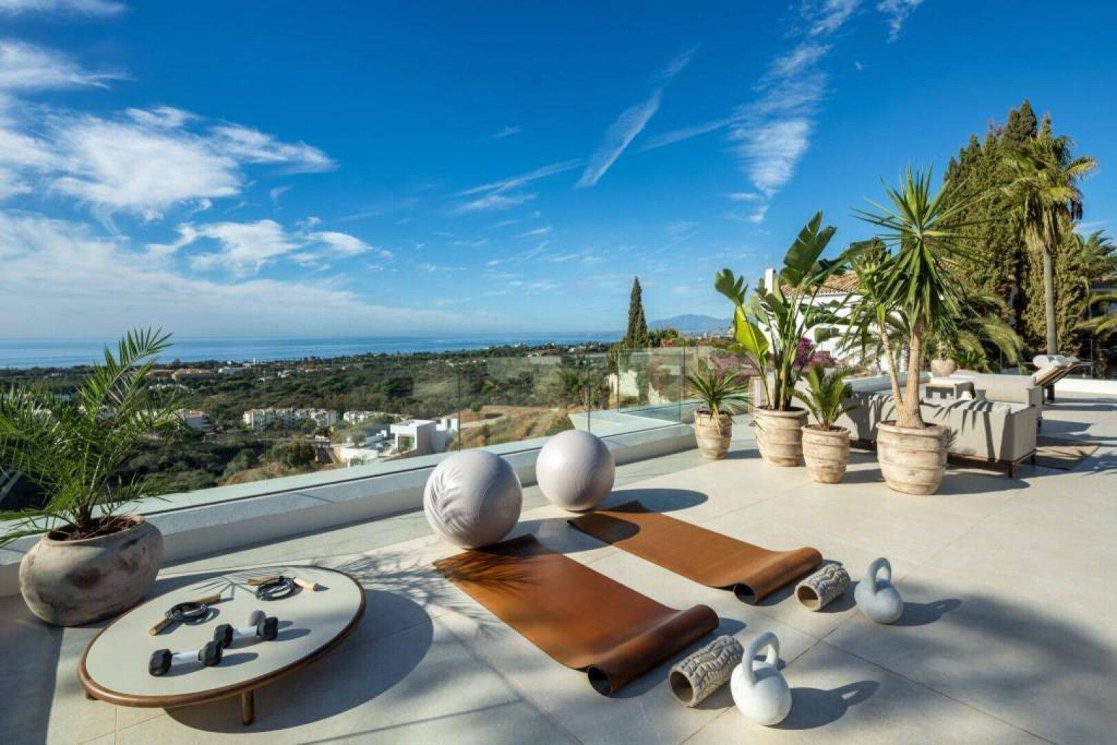 Sonniger Terrassenbereich mit Meerblick, ideal für Yoga und Fitness im Freien.