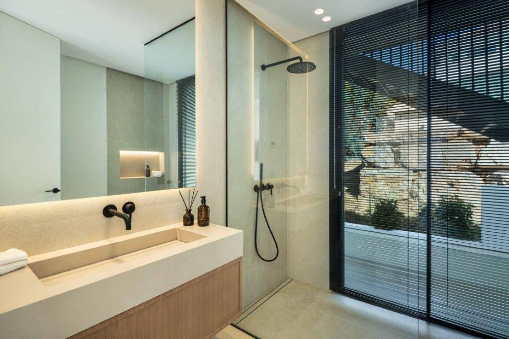 Elegantes Badezimmer mit begehbarer Dusche, großem Spiegel und modernen Armaturen.