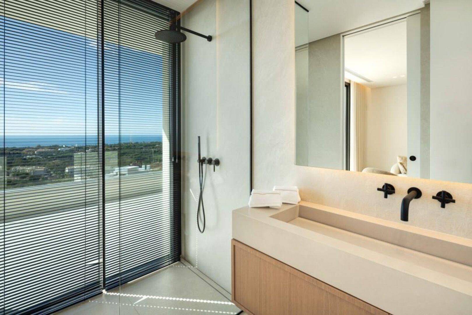 Modernes Badezimmer mit Meerblick, begehbarer Dusche und stilvollem Waschtisch.