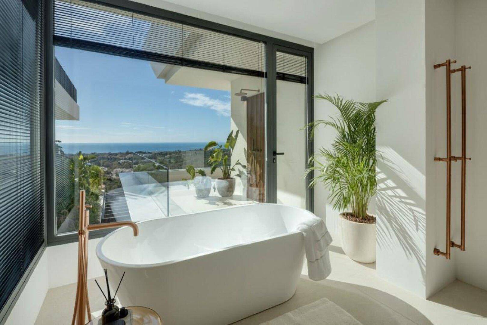 Elegantes Badezimmer mit freistehender Badewanne und Panoramafenstern, die einen atemberaubenden Meerblick bieten.