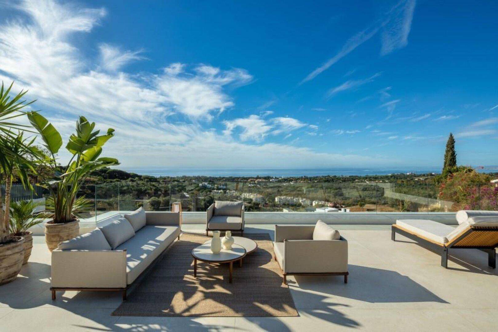 Weitläufige Dachterrasse mit stilvollen Lounge-Möbeln und einem beeindruckenden Panoramablick auf das Meer.