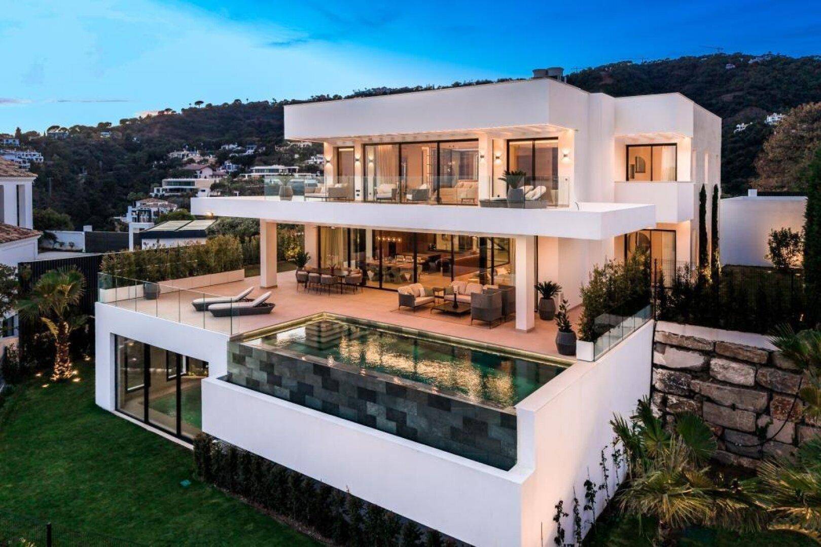 Elegante moderne Villa mit mehreren Ebenen, großen Glasfronten und Infinity-Pool.
