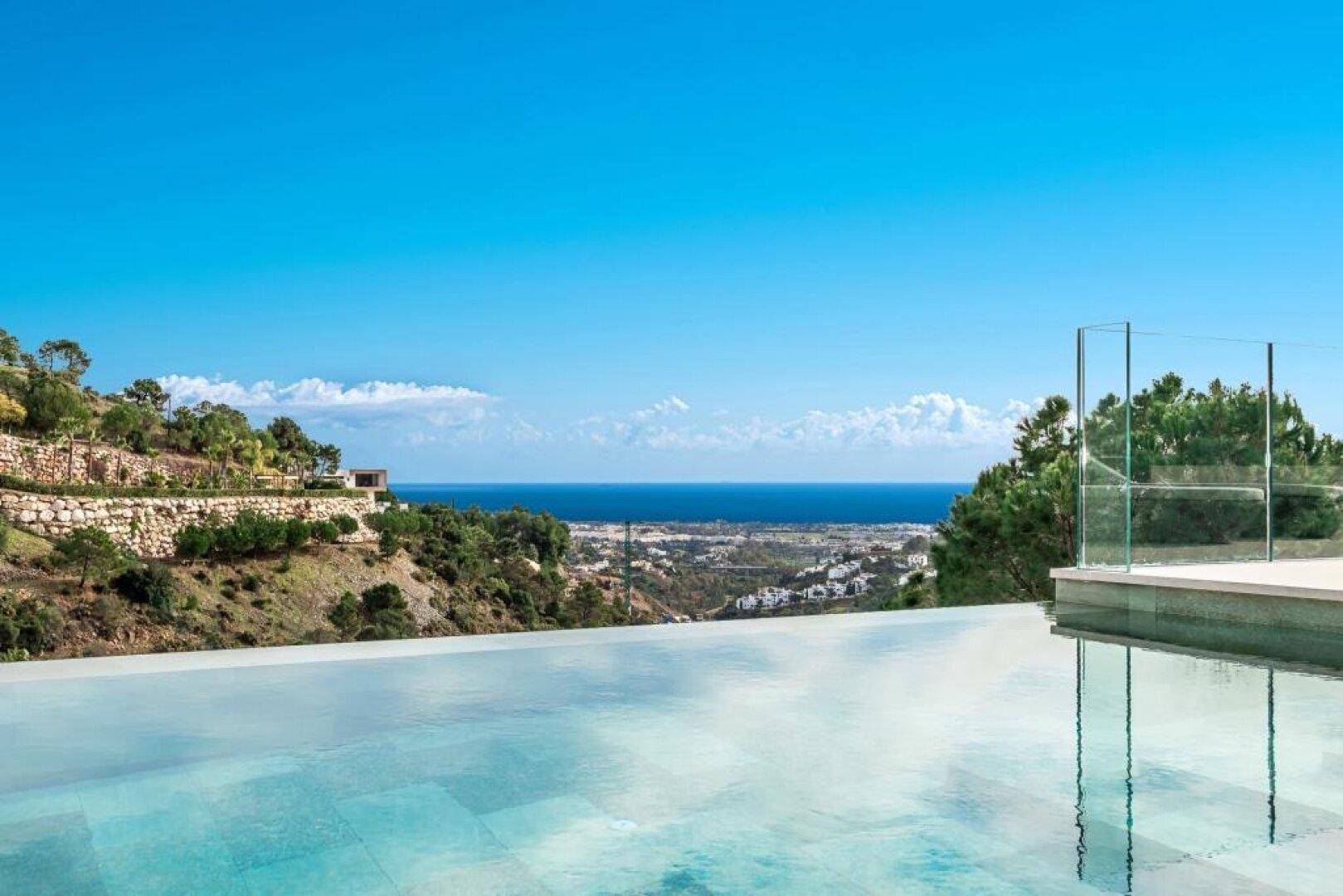Infinity-Pool mit weitem Blick auf das Meer und die grüne Hügellandschaft.