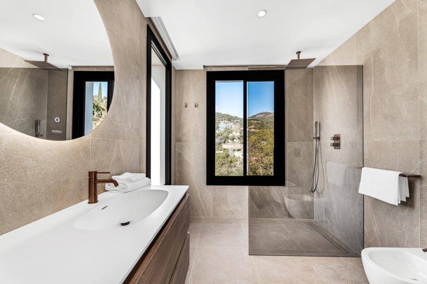 Elegantes Badezimmer mit großer begehbarer Dusche, Einzelwaschbecken und Fenster mit Bergblick.