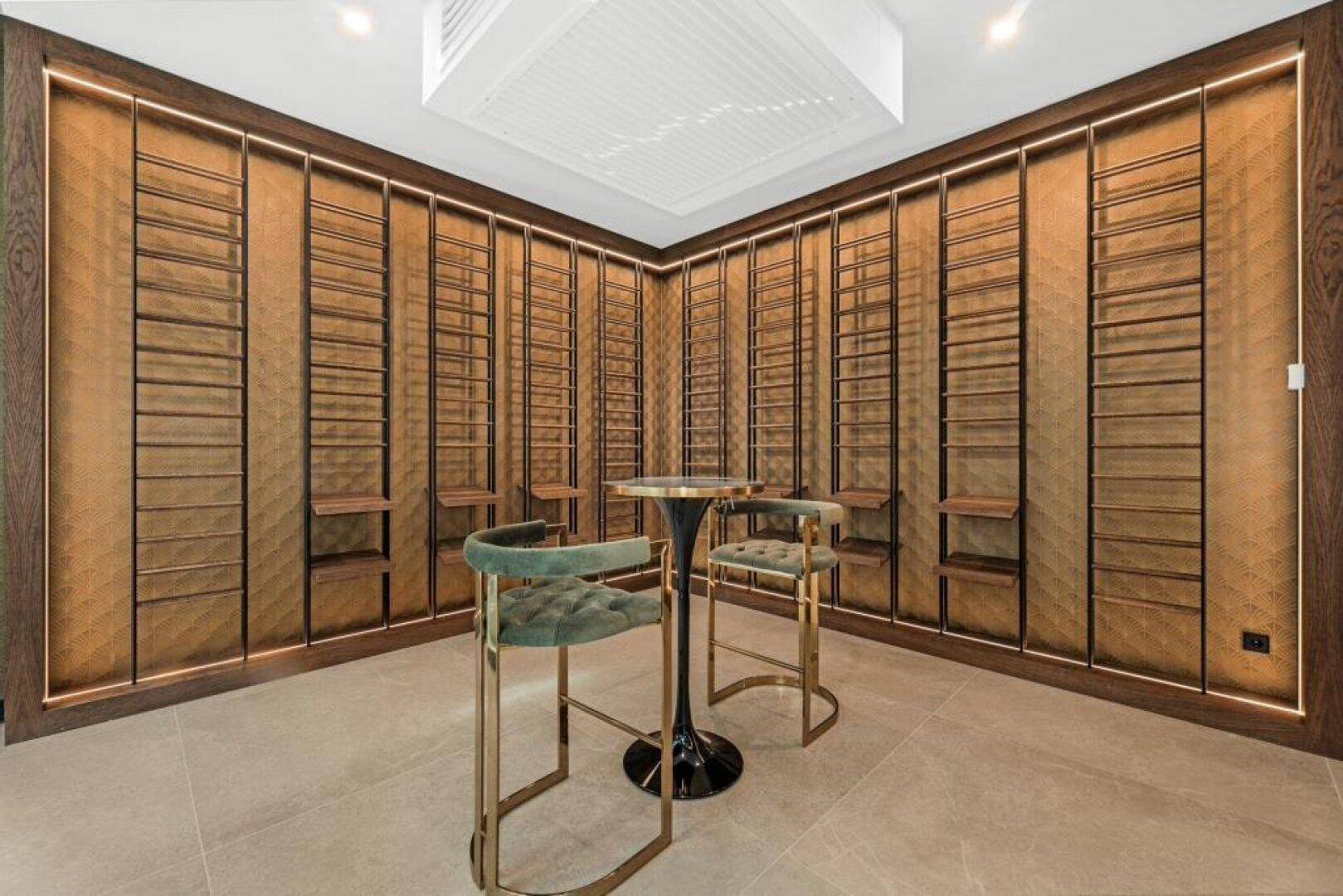 Exklusiver Weinkeller mit eleganten Regalen, Bartisch und stilvollen Barhockern.
