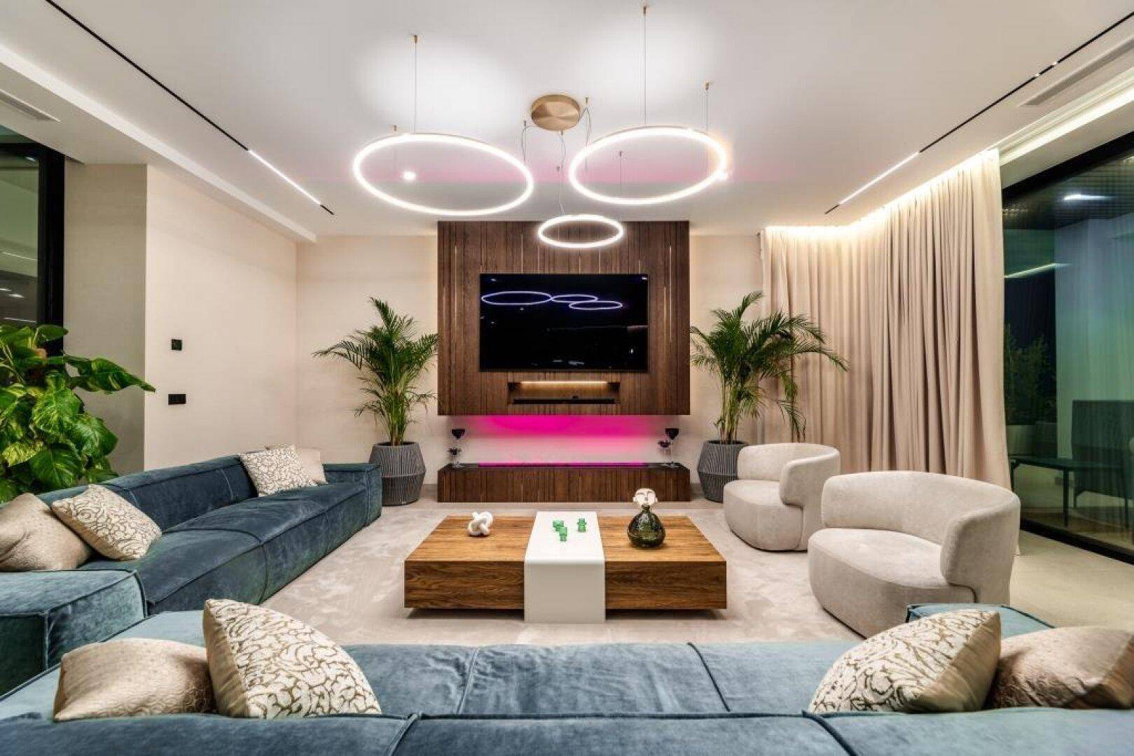 Geräumiges Wohnzimmer mit bequemen Sofas, modernem Couchtisch und indirekter Beleuchtung.