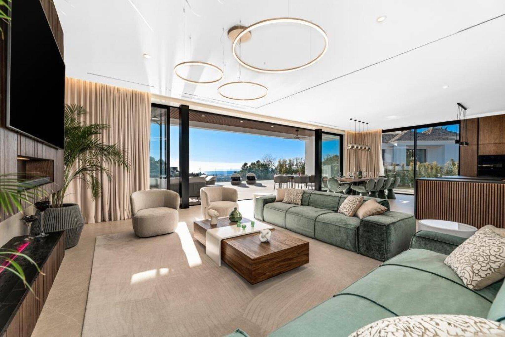 Helles Wohnzimmer mit Meerblick, modernen Möbeln und Zugang zur großzügigen Terrasse.