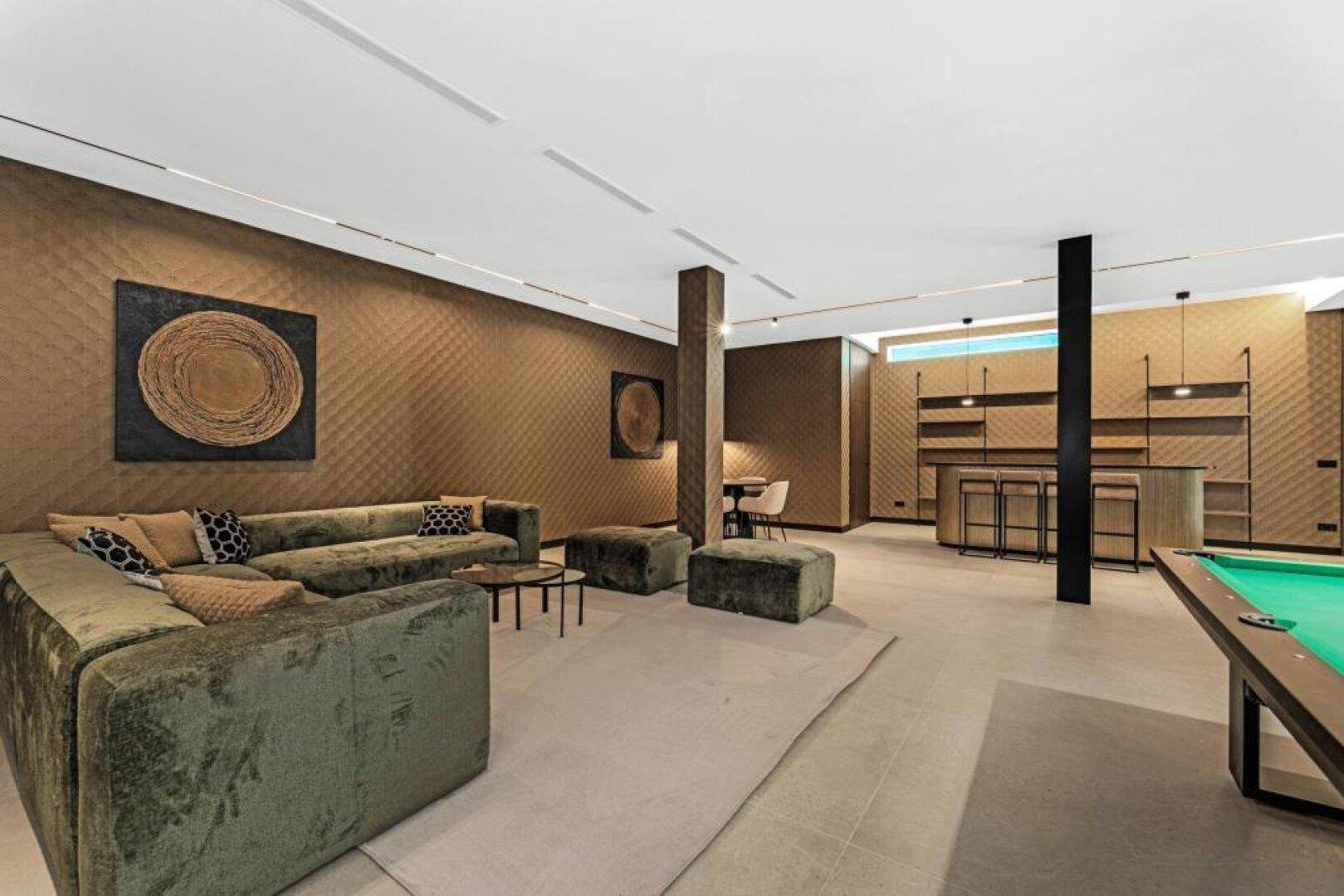Geräumiger Unterhaltungsbereich mit bequemen Sofas, Bar und Billardtisch für gesellige Stunden.