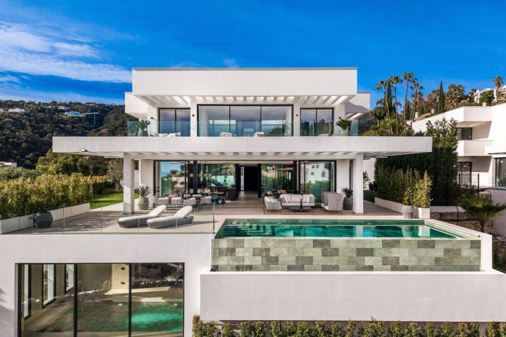 Luxuriöse moderne Villa bei Tageslicht mit mehreren Terrassen und großem Pool, sehr weitläufig.