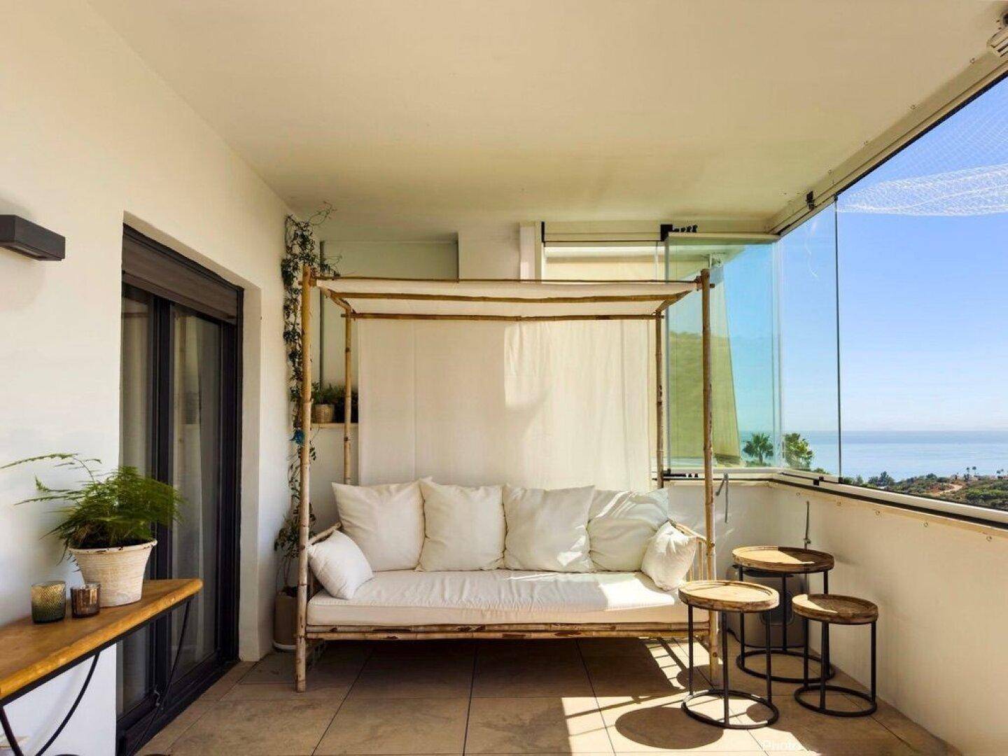Sonniger Terrassenbereich mit Tagesbett und Meerblick, ideal zum Entspannen.