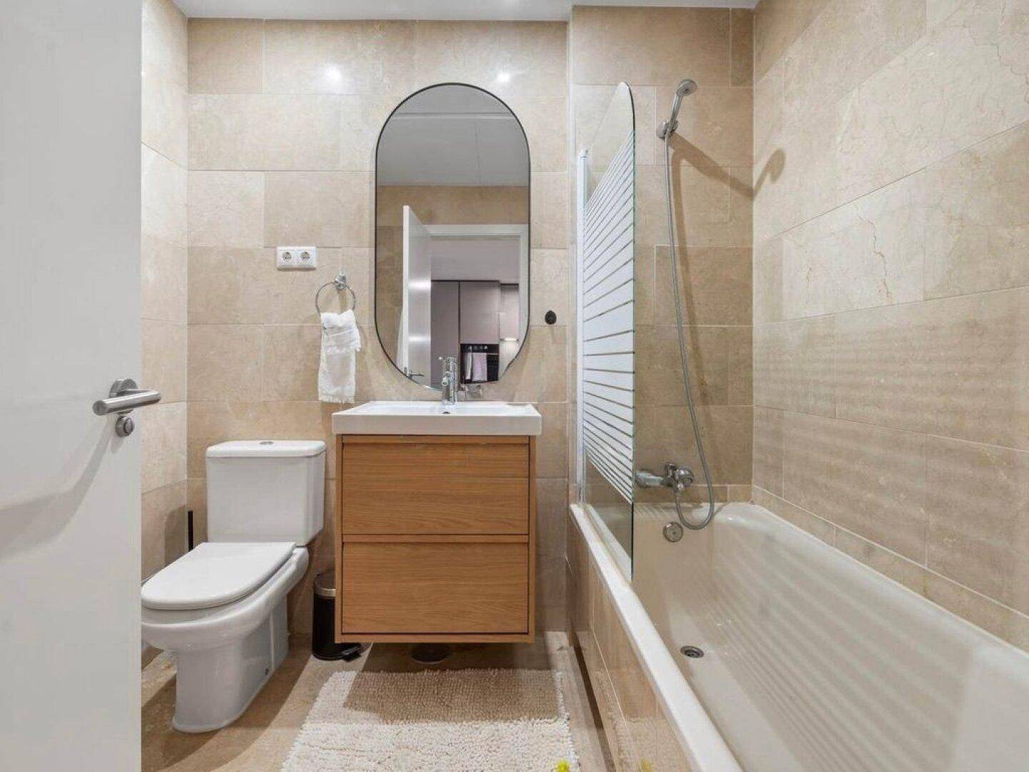 Modernes Badezimmer mit Badewanne, Dusche und schwebendem Waschtisch.