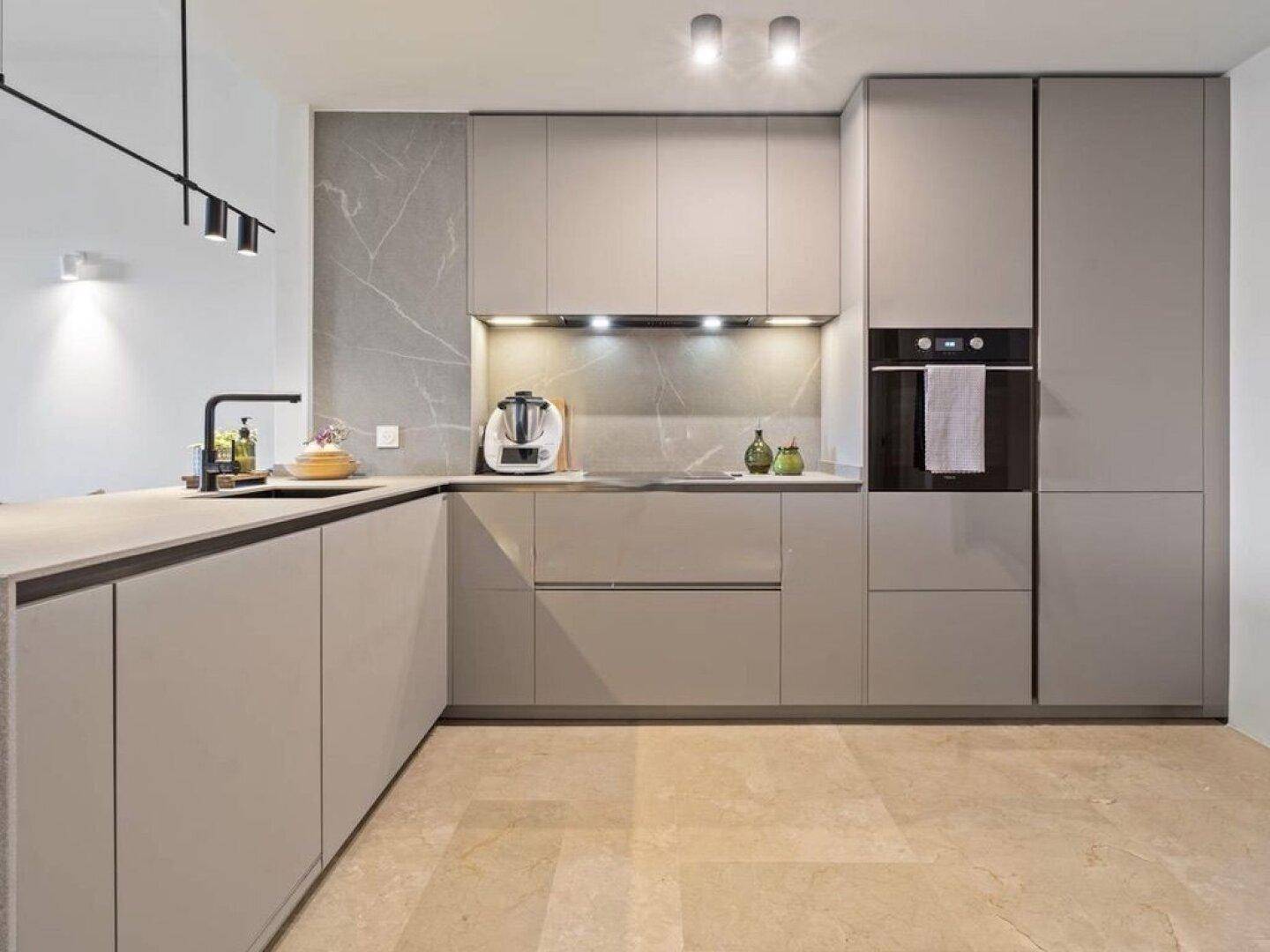 Elegante, moderne Küche in Grau mit integrierten Geräten und viel Stauraum.