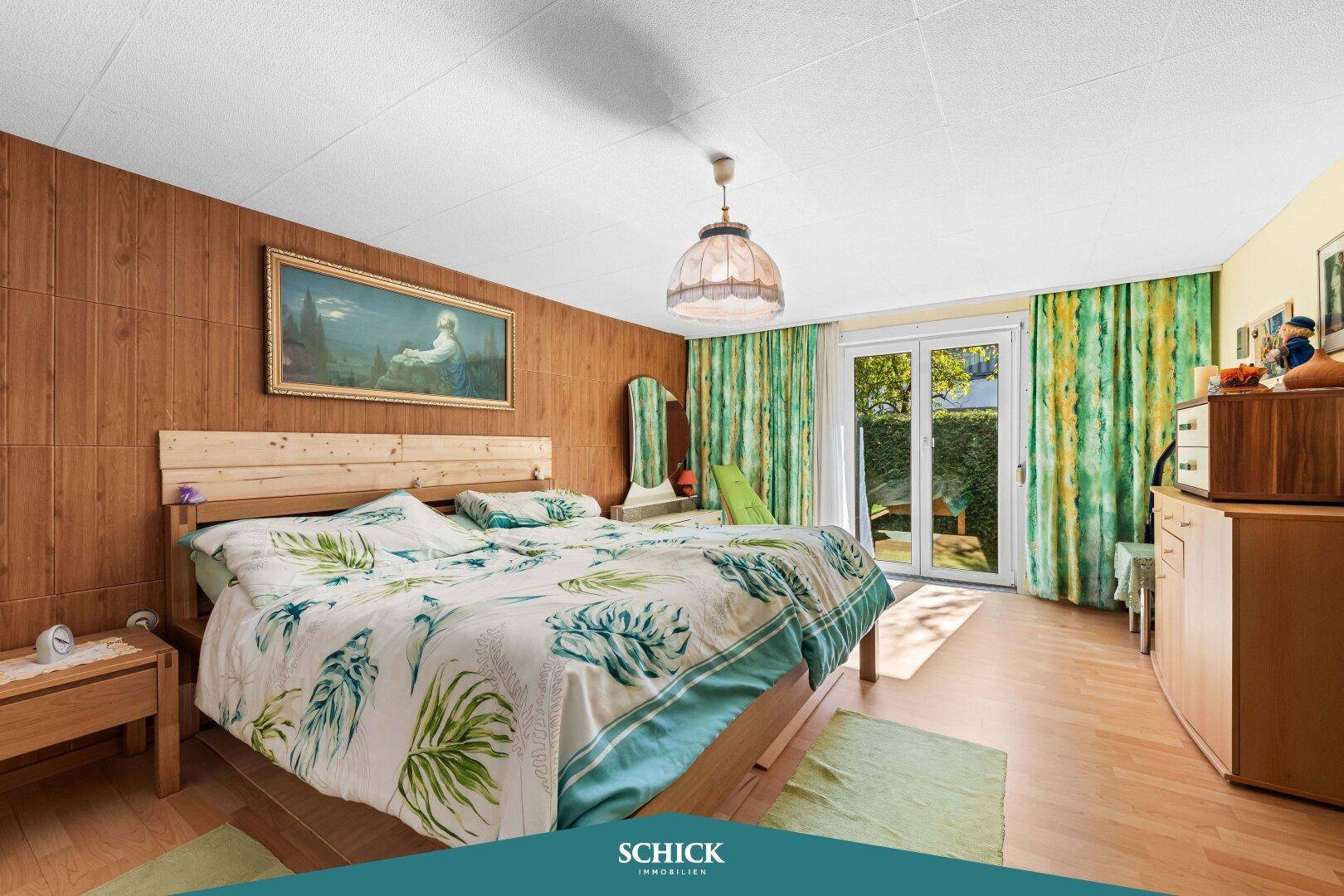 Gemütliches Schlafzimmer mit Holzwänden, Parkettboden und Zugang zum Garten.