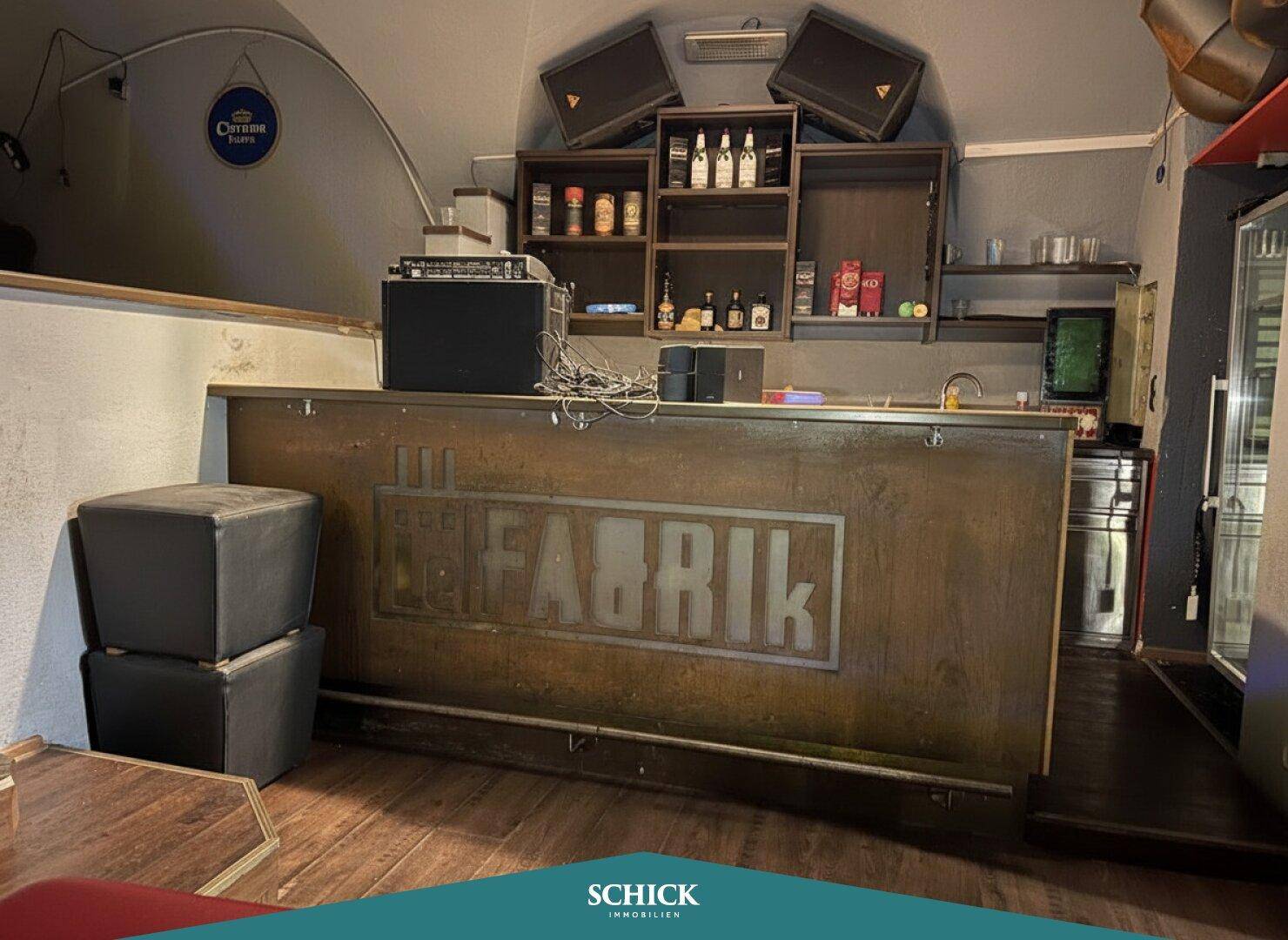 Eine weitere Bar mit rustikaler Holztheke und Regalen, die eine gemütliche Atmosphäre schafft.