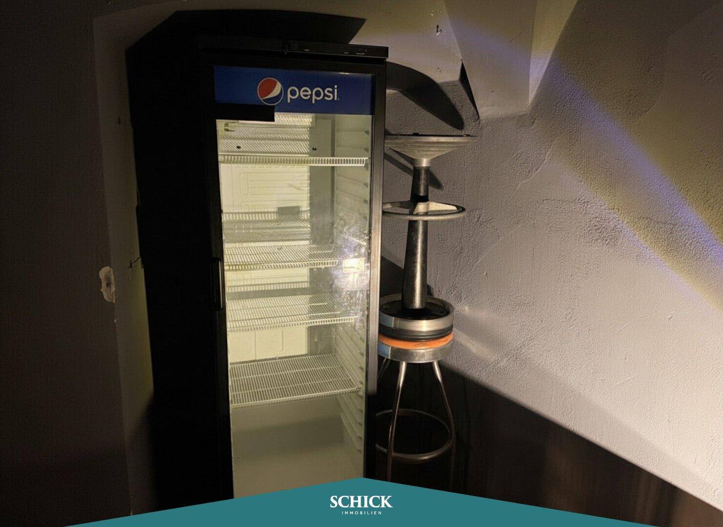 Leerer kommerzieller Kühlschrank in einem Lagerbereich, bereit zur Befüllung mit Getränken.
