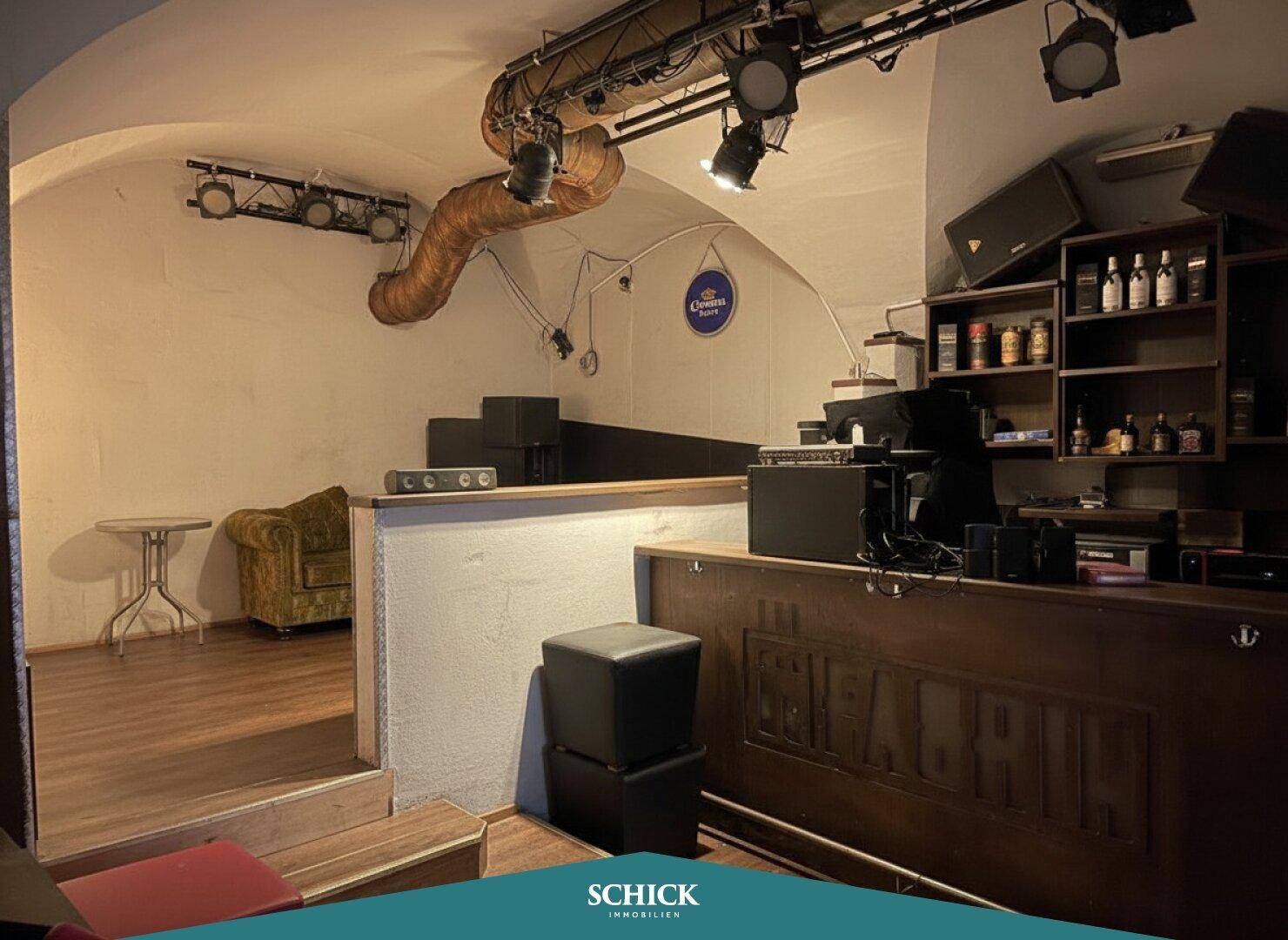 Barbereich mit Sitzgelegenheiten, gewölbter Decke und Beleuchtung, die eine einladende Stimmung erzeugt.