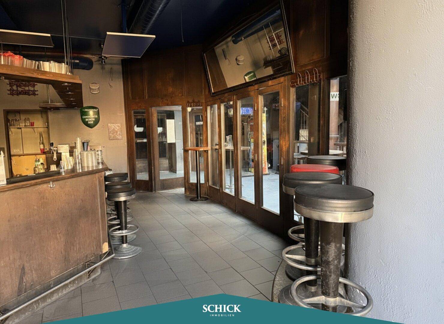Innenansicht einer Bar mit Theke, Barhockern und gefliestem Boden, bereit für Gäste.