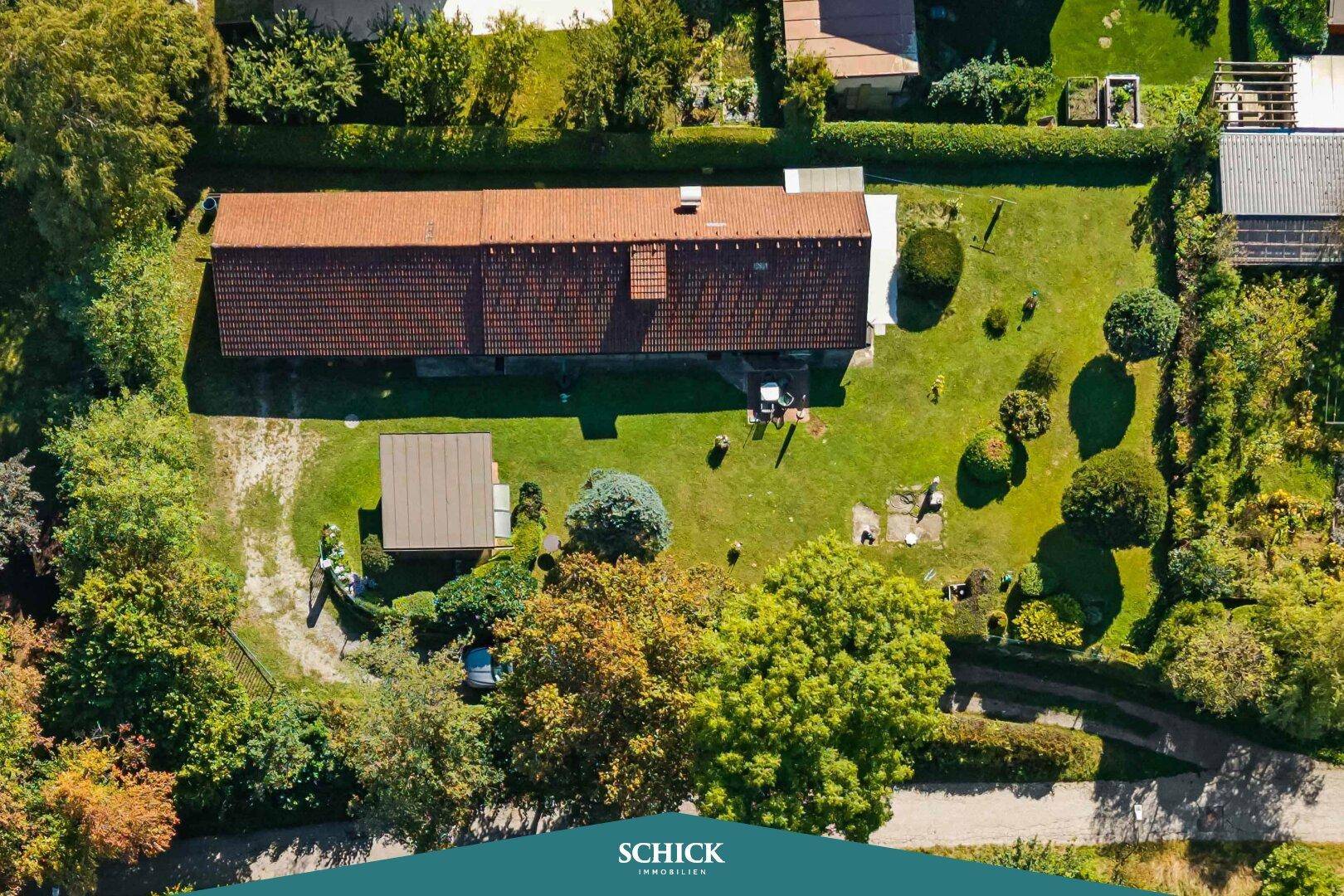 Draufsicht auf das Anwesen mit weitläufigem, gepflegtem Garten und altem Baumbestand.