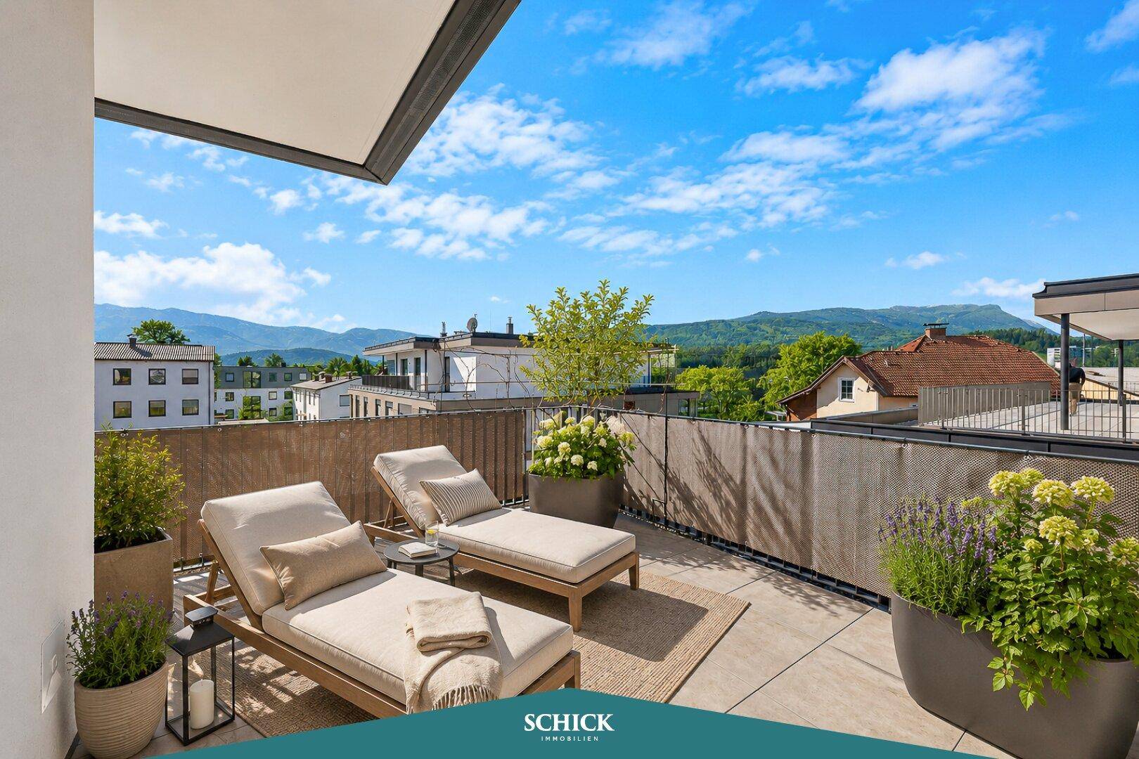 Großer Balkon mit bequemen Sonnenliegen und Pflanzen, ideal zum Entspannen mit Bergblick.