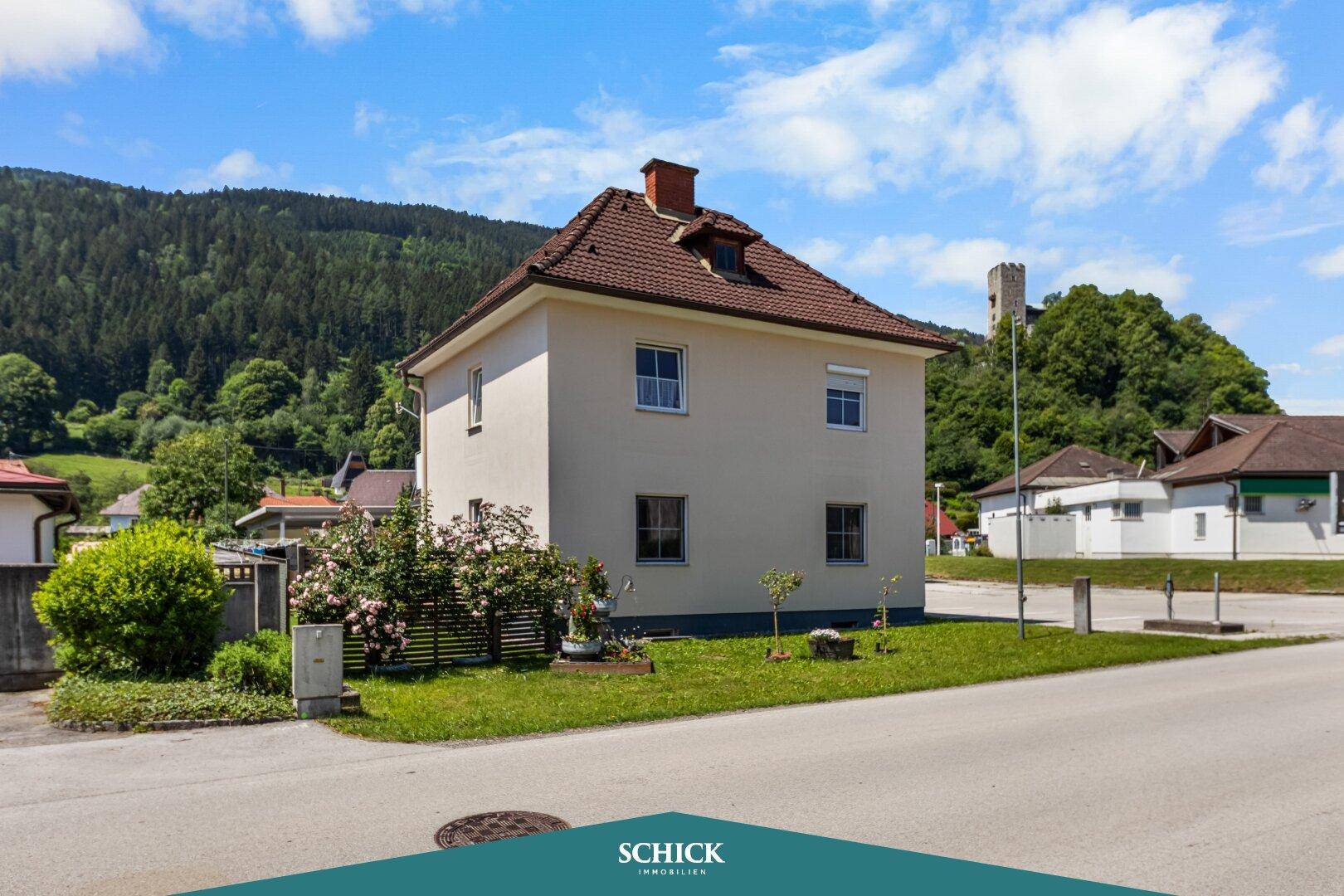 Seitenansicht des Hauses mit Gartenbereich und Blick auf die umliegende grüne Landschaft.