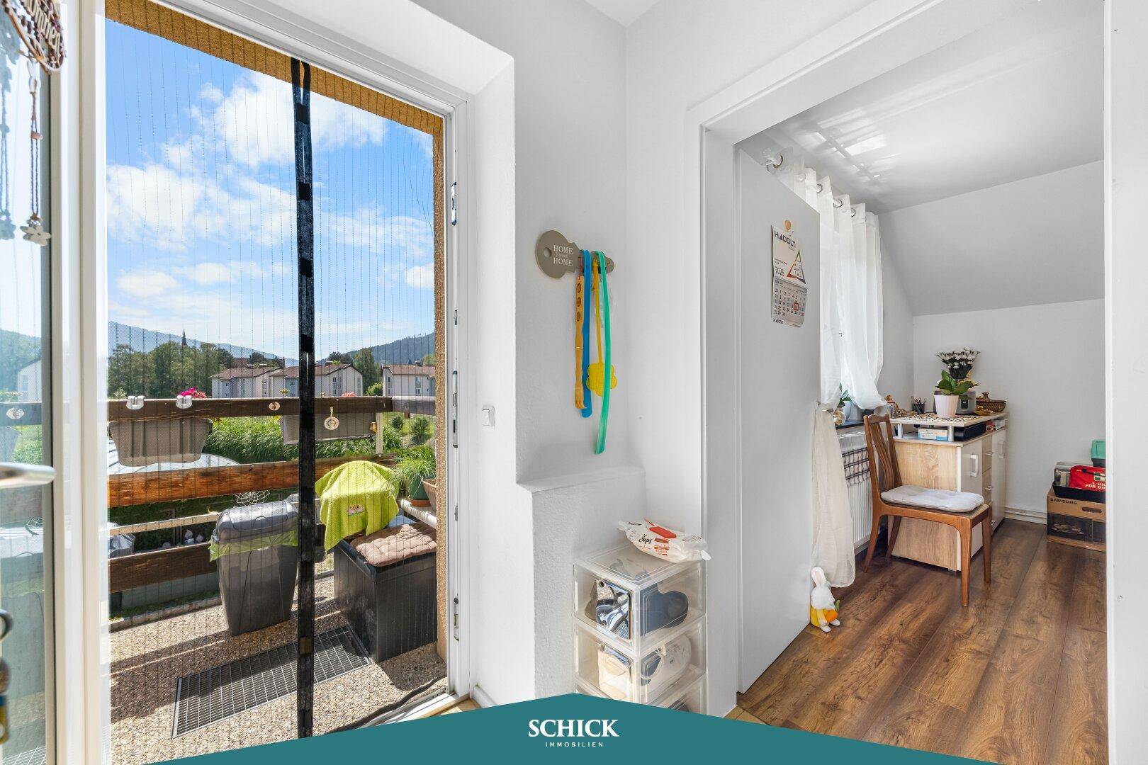 Heller Flur mit Zugang zu einem Balkon und einem weiteren Zimmer, ausgestattet mit Laminatboden.