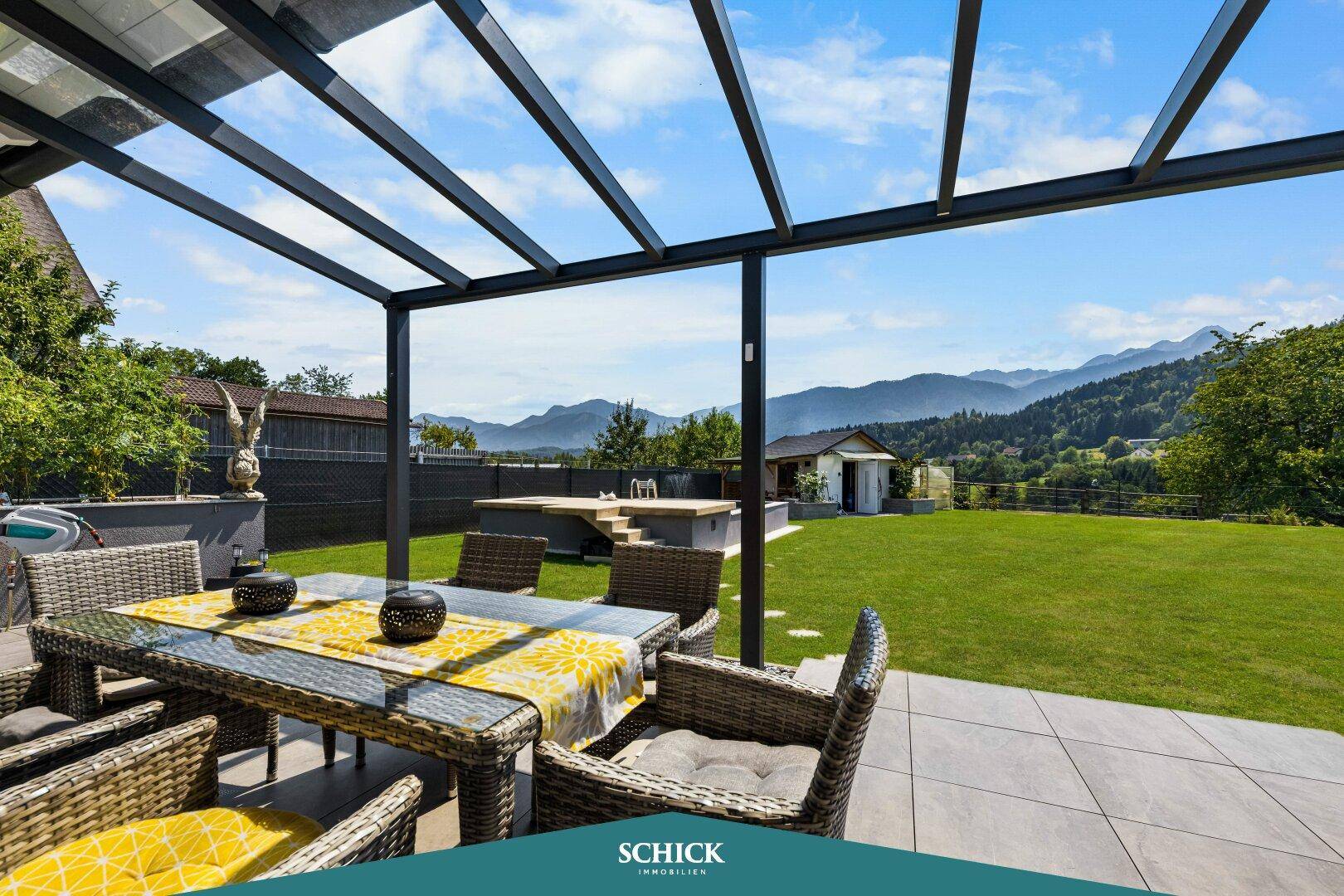 Überdachte Terrasse mit Esstisch und Stühlen, bietet einen herrlichen Bergblick.
