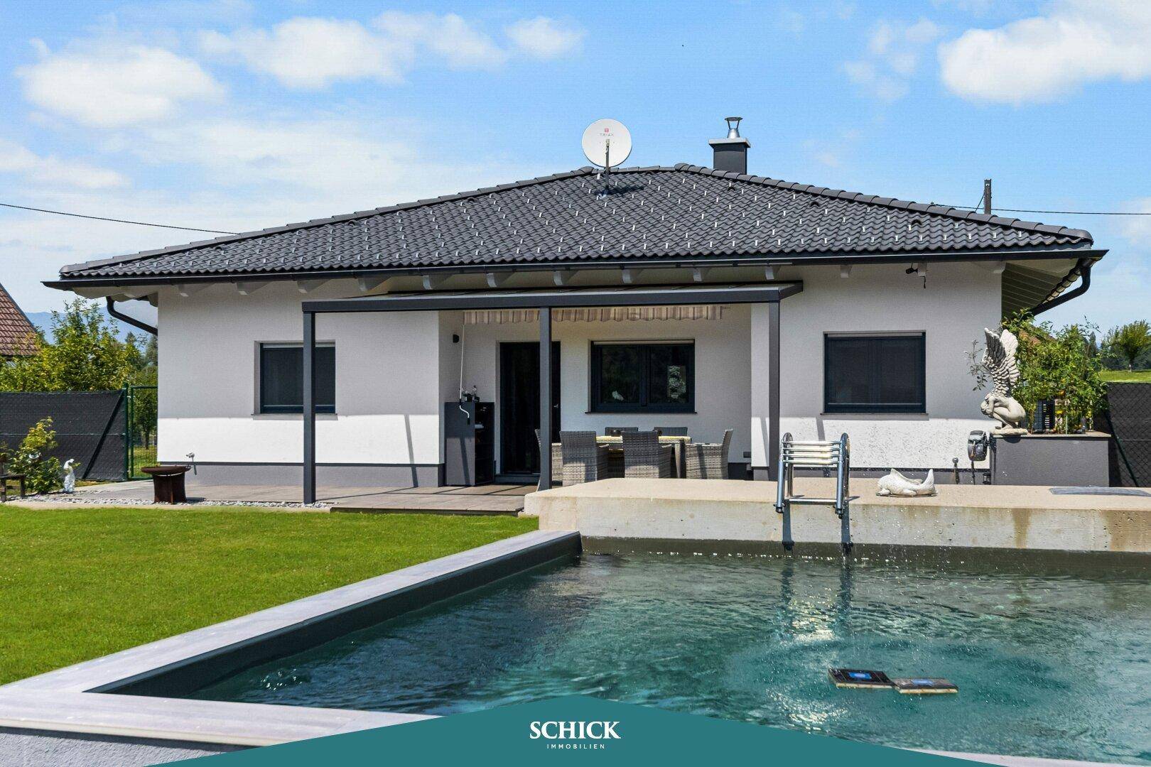 Gepflegter Gartenbereich mit Swimmingpool und Terrasse hinter dem modernen Haus.