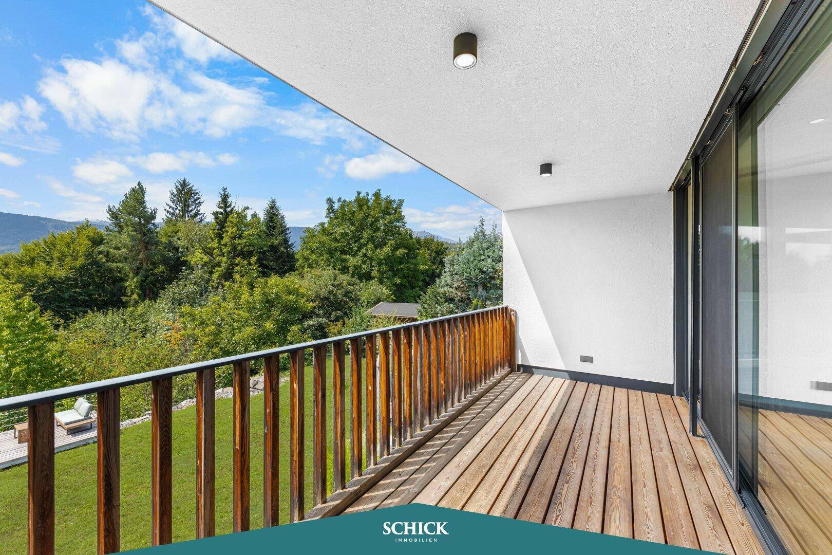 Großer Balkon mit Holzboden und Geländer, ideal zum Entspannen mit Bergblick.