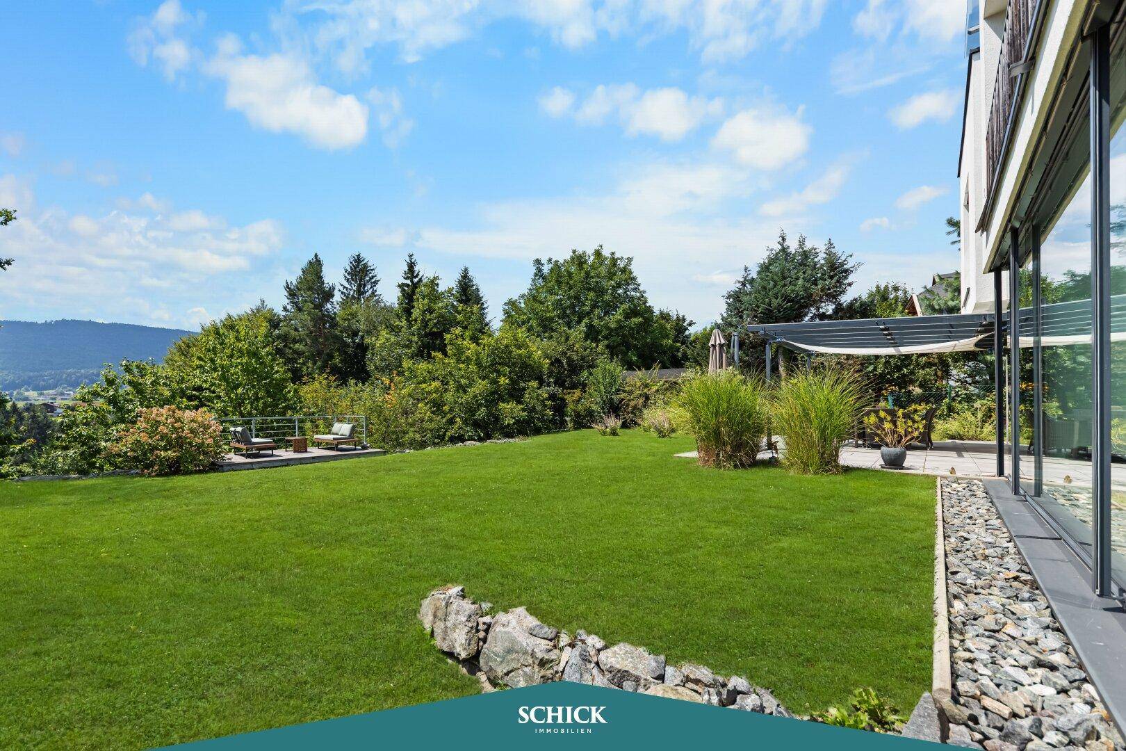 Weitläufiger Garten mit gepflegtem Rasen und Blick auf die grüne Hügellandschaft.