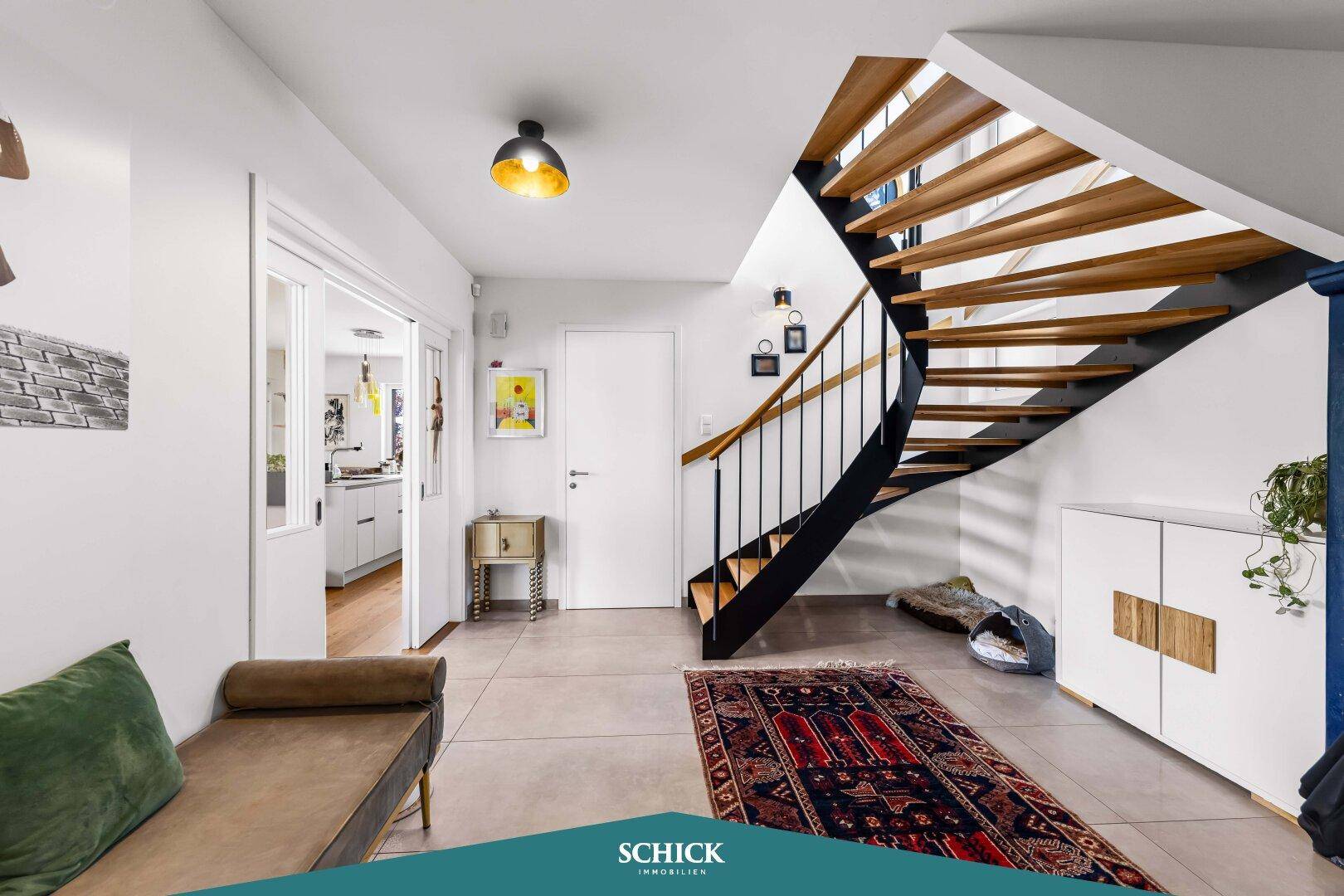 Geräumiger Flur mit eleganter Holztreppe und modernem Design, der verschiedene Bereiche verbindet.