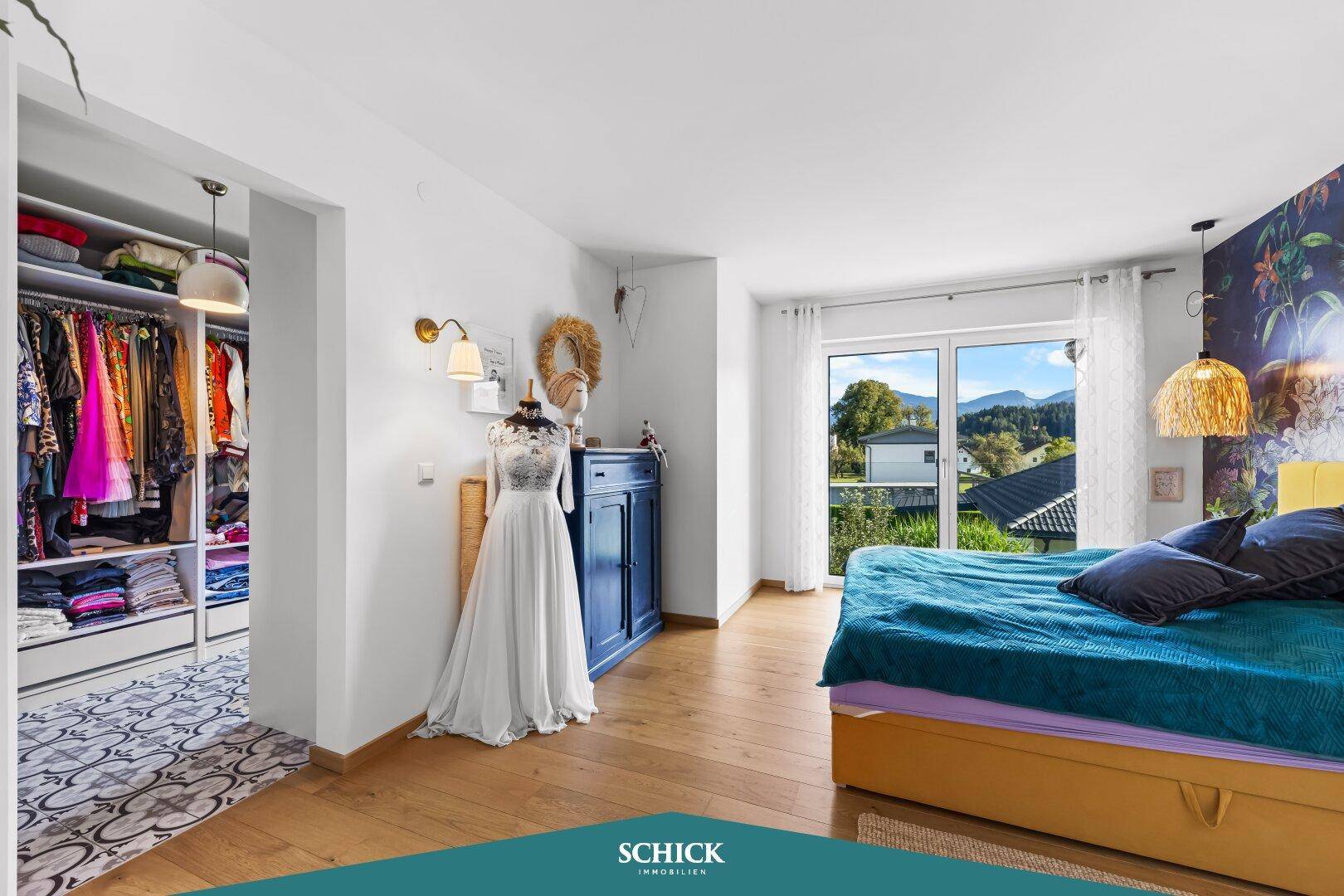 Geräumiges Schlafzimmer mit Doppelbett, Balkonzugang und offenem Übergang zum begehbaren Kleiderschrank.