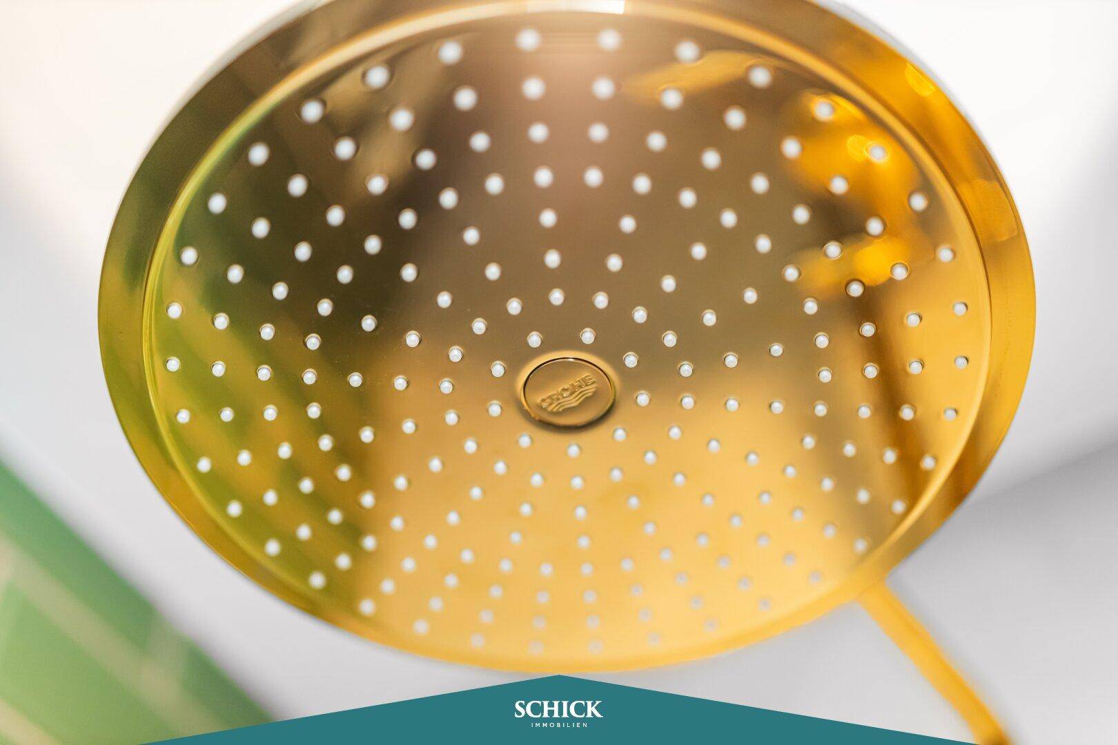 Nahaufnahme des goldenen Regenduschkopfes, der ein luxuriöses Duscherlebnis verspricht.