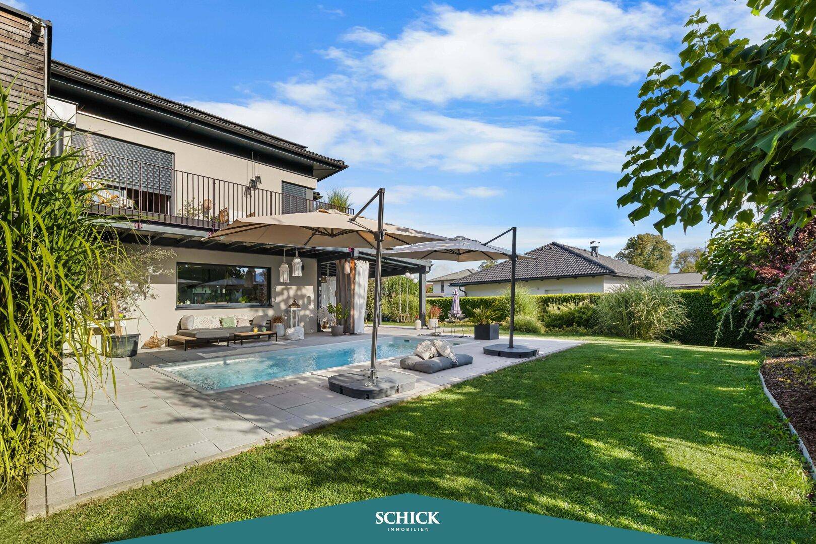 Weitläufiger Garten mit Rasenfläche, Pool und mehreren Sonnenschirmen für Entspannung im Freien.