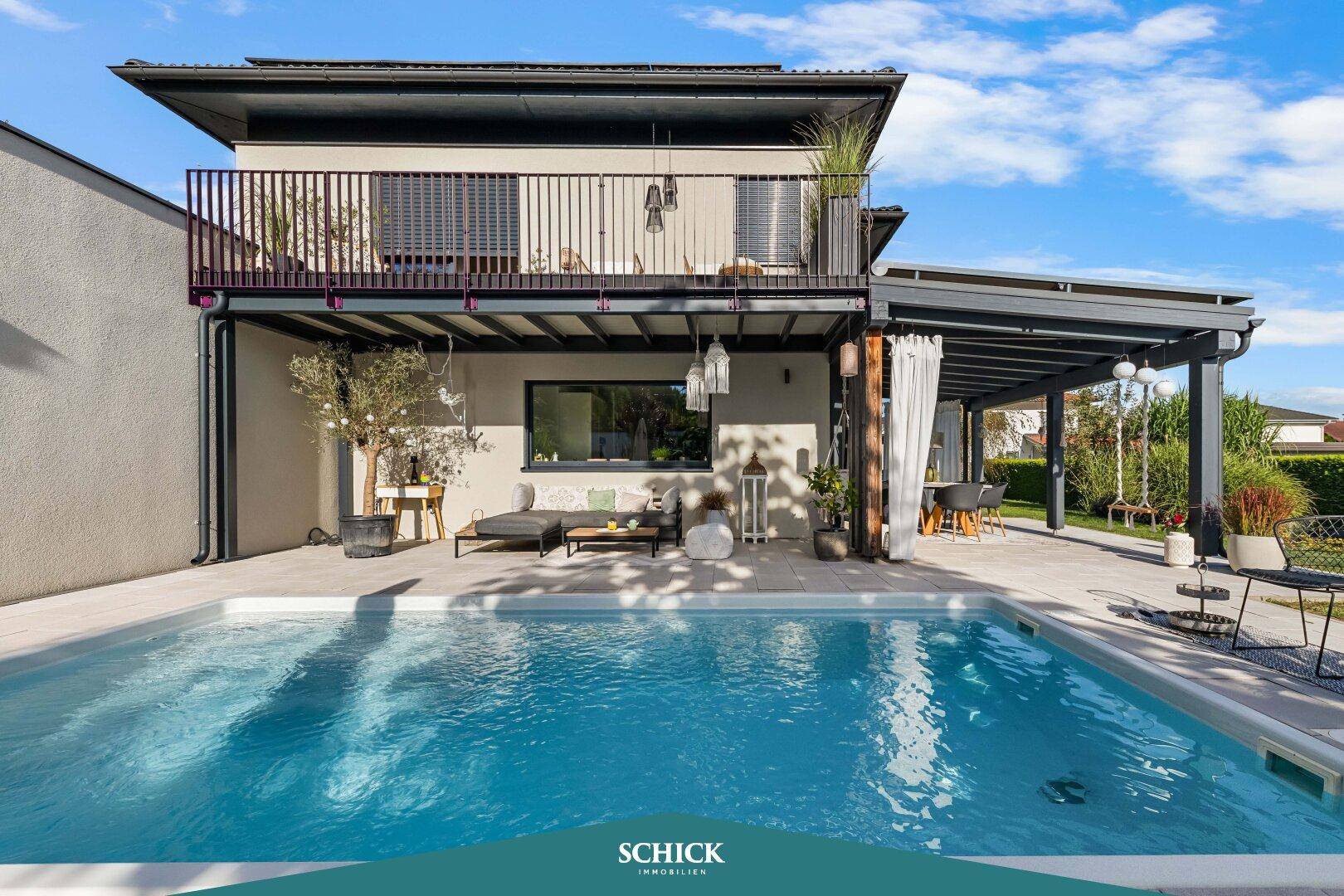 Ansicht des modernen Hauses mit großem Pool, überdachter Terrasse und Balkon im Obergeschoss.