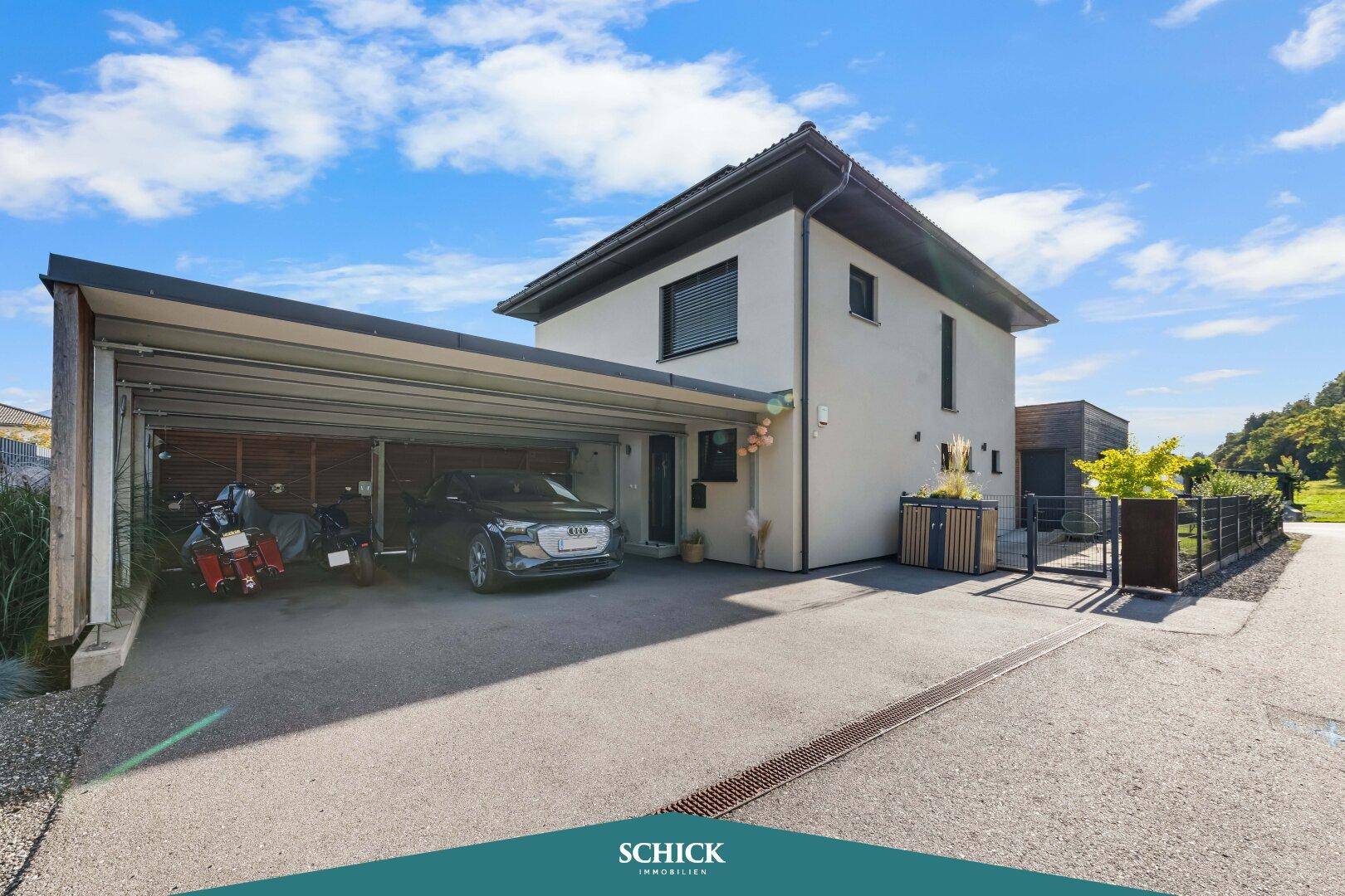 Modernes Einfamilienhaus mit großem Carport und einem gepflegten Vorgartenbereich.