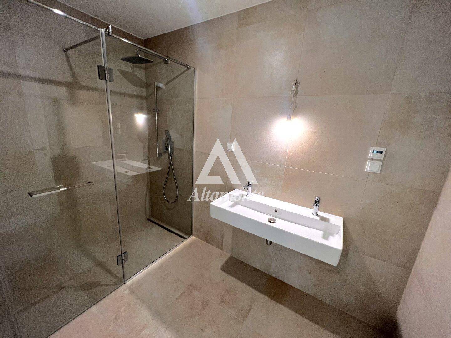 Modernes Badezimmer mit begehbarer Dusche, eleganten Fliesen und einem schwebenden Waschbecken.