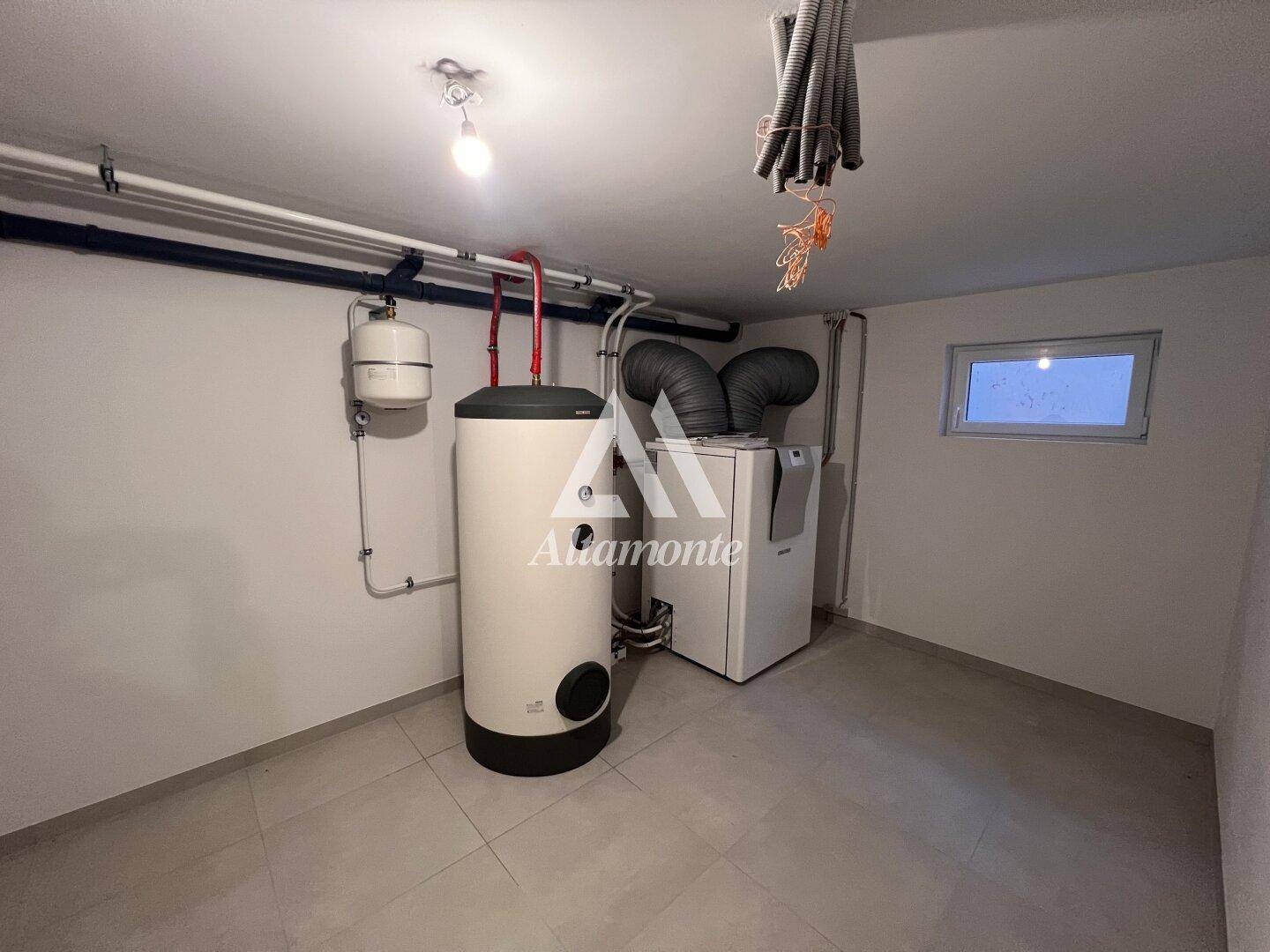 Hauswirtschaftsraum im Keller mit Heizungsanlage, Warmwasserspeicher und Fliesenboden.
