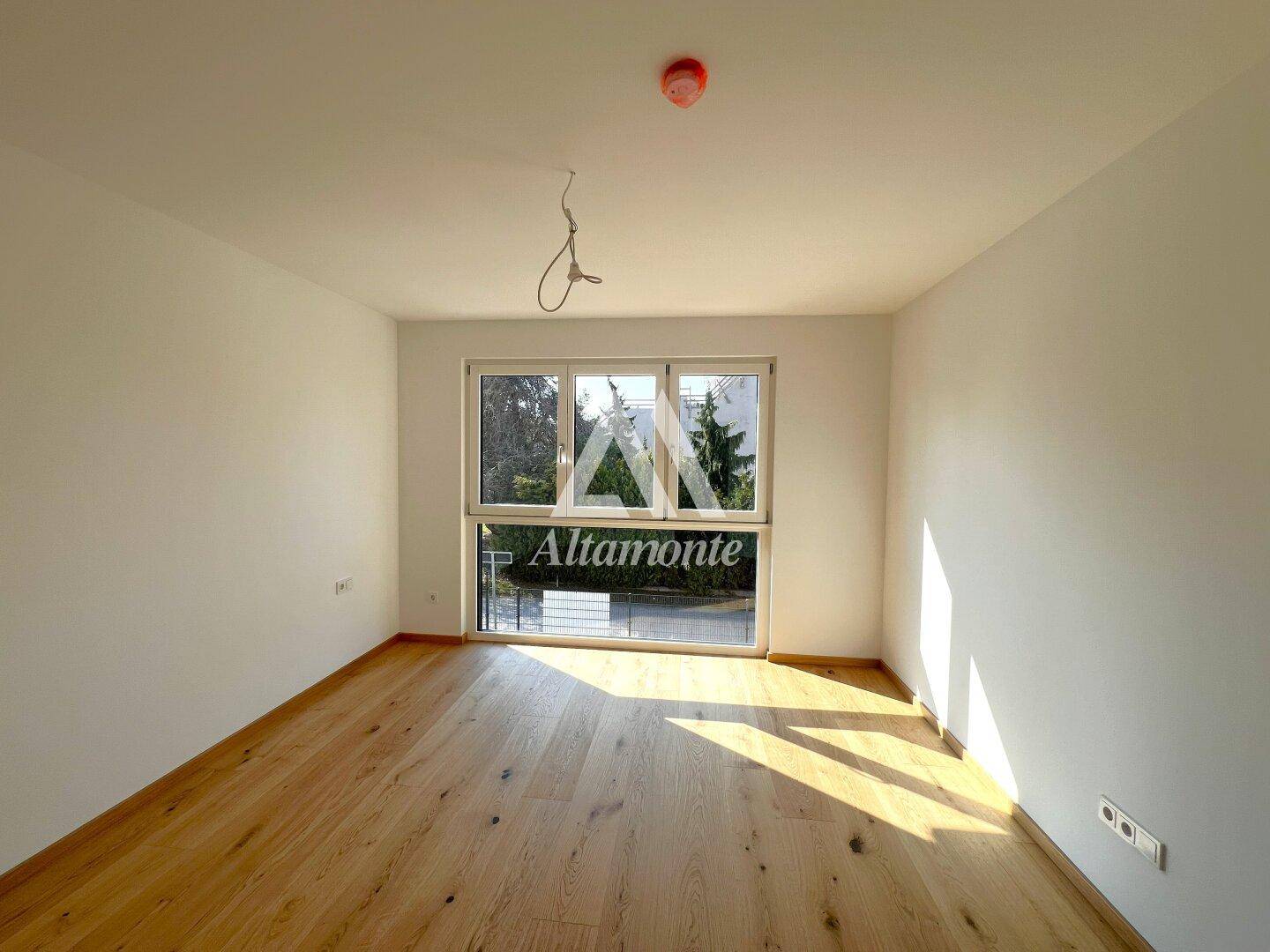 Geräumiges Zimmer mit großen Fenstern und Eichenparkett, bietet viel natürliches Licht.