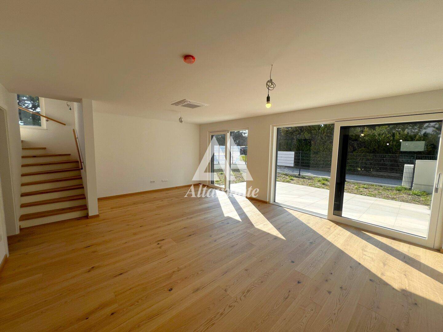 Helles und geräumiges Wohnzimmer mit Eichenparkettboden und Zugang zur Terrasse.