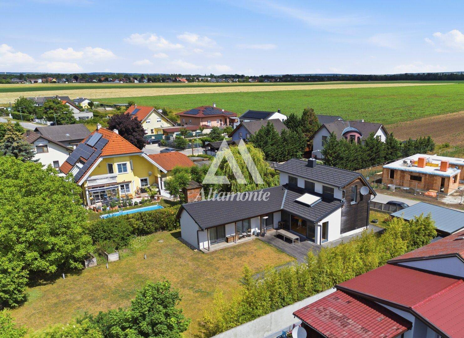 Luftaufnahme des Anwesens mit Pool, Garten und umliegender ländlicher Bebauung.