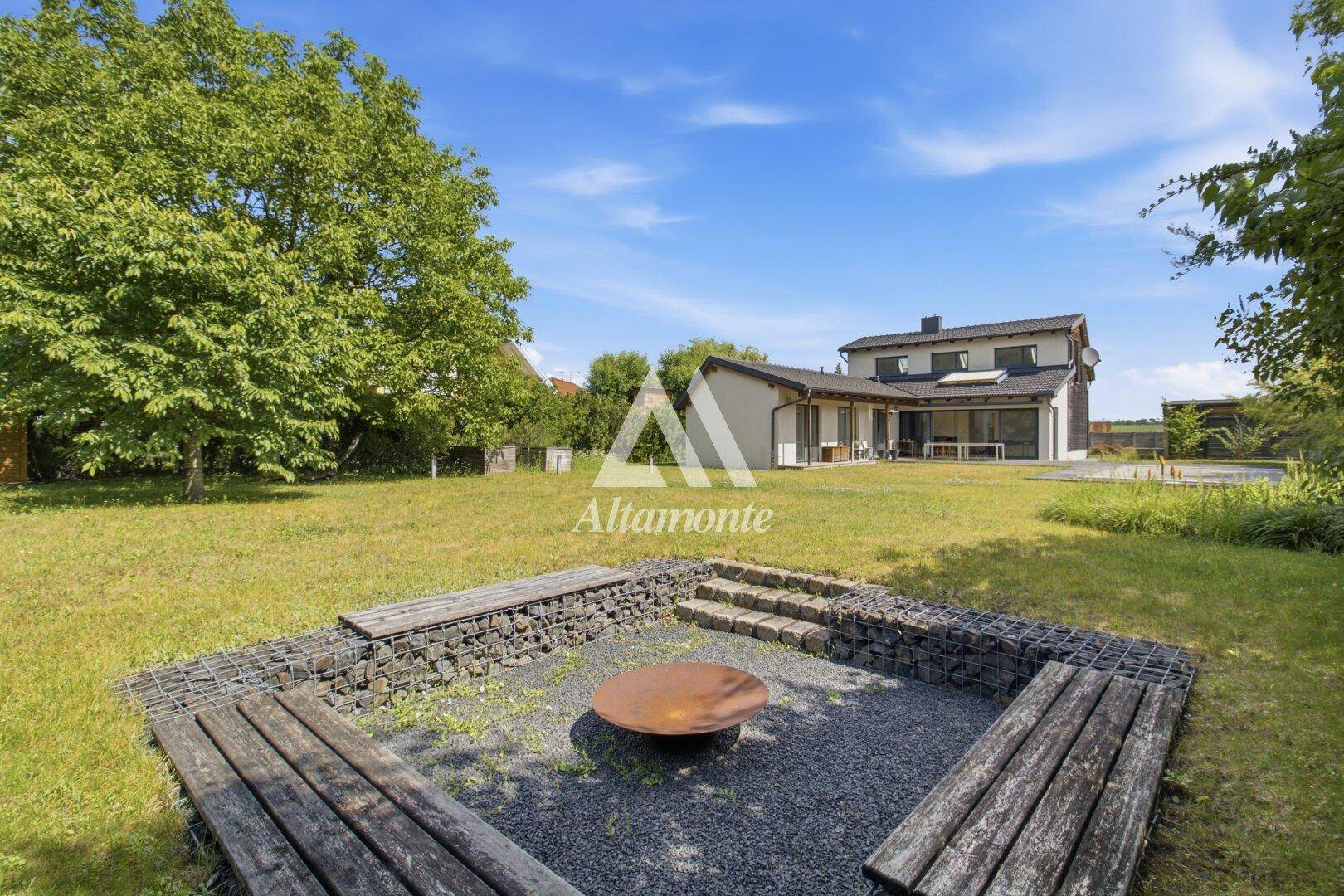 Großer Garten mit Feuerstelle und Sitzgelegenheiten, ideal für Abende im Freien.