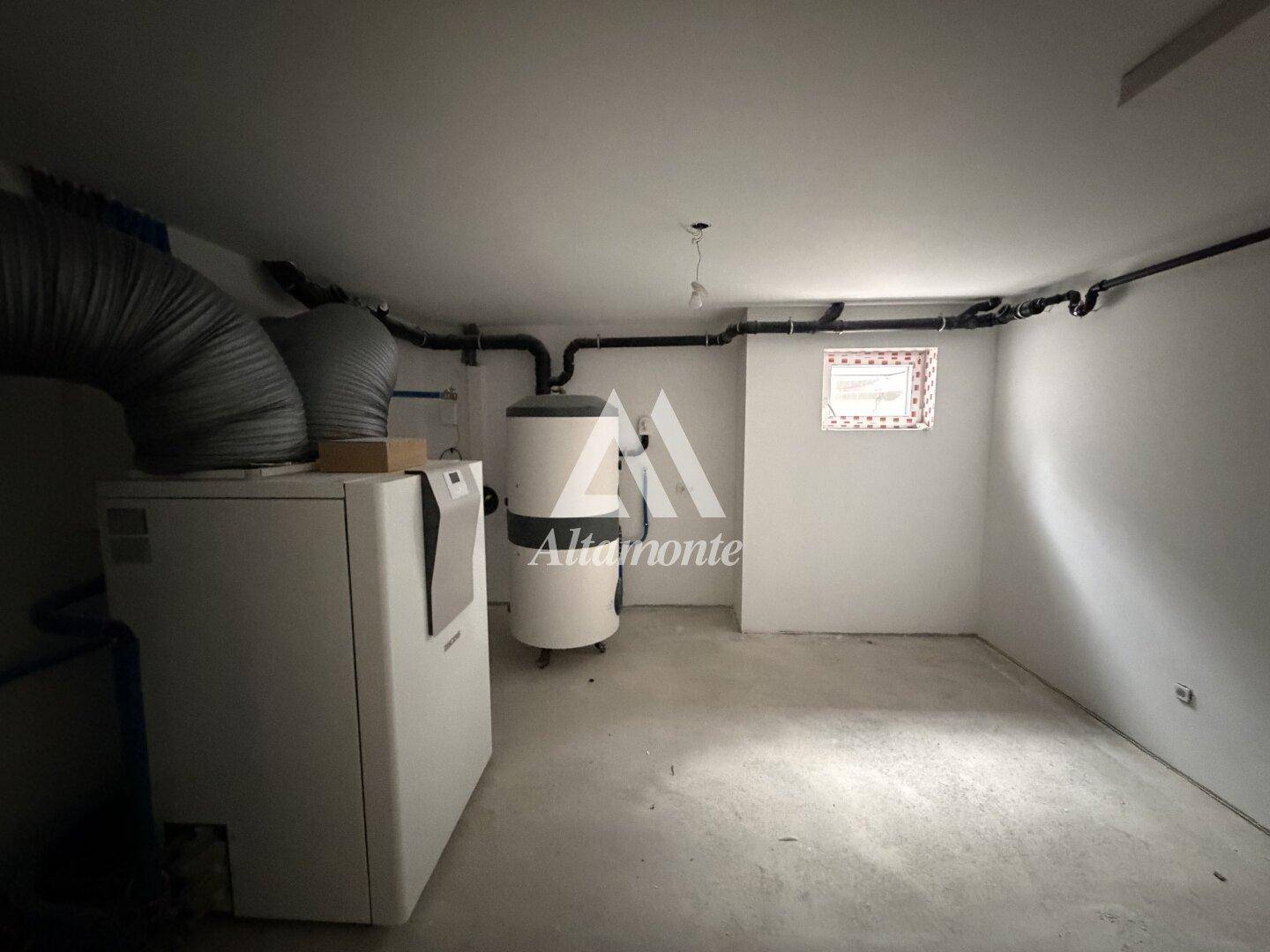 Technikraum im Keller mit Heizungsanlage und Warmwasserspeicher.