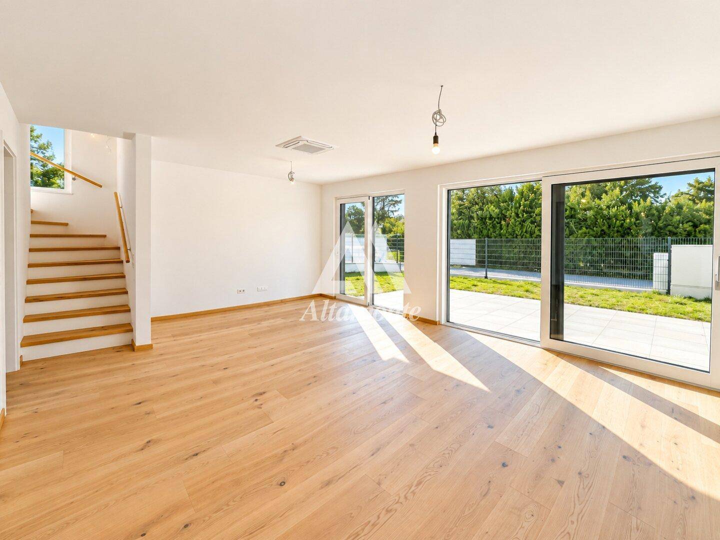 Helles Wohnzimmer mit Eichenparkett, großen Schiebetüren und Zugang zur Terrasse.