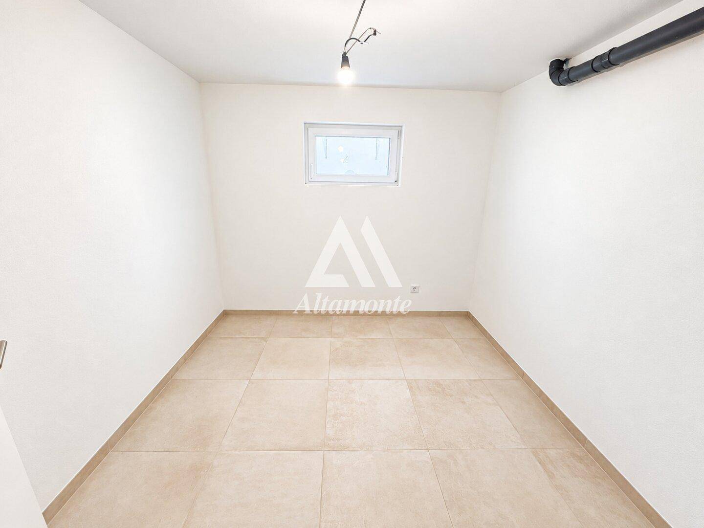 Funktionaler Abstellraum im Untergeschoss mit Fliesenboden und kleinem Fenster.